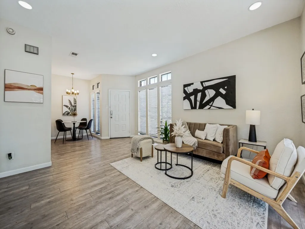 Wood-finish flooring throughout, recessed lighting, and a front door with sidelight windows
