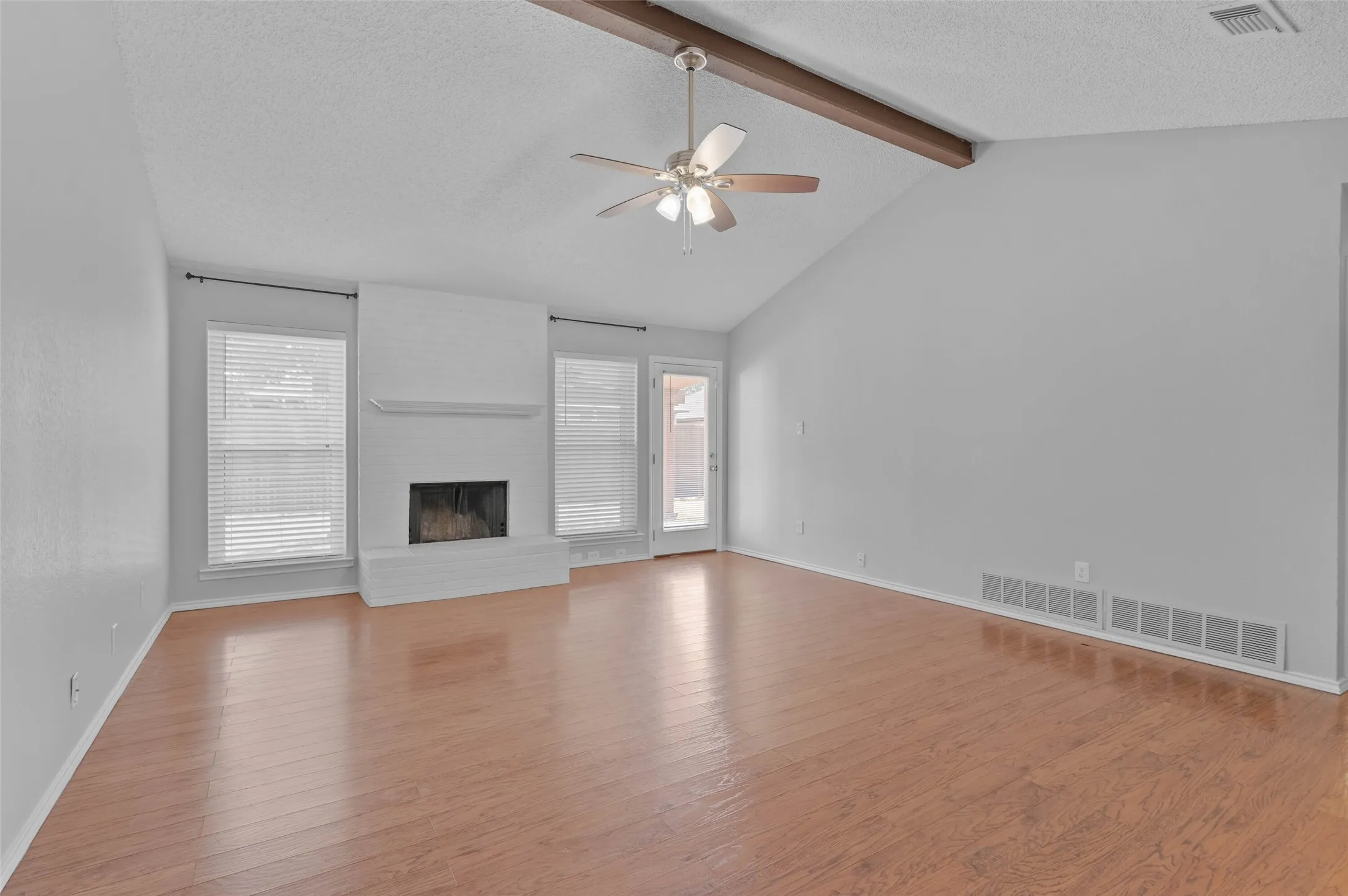 Living room with vaulted ceiling and fireplace