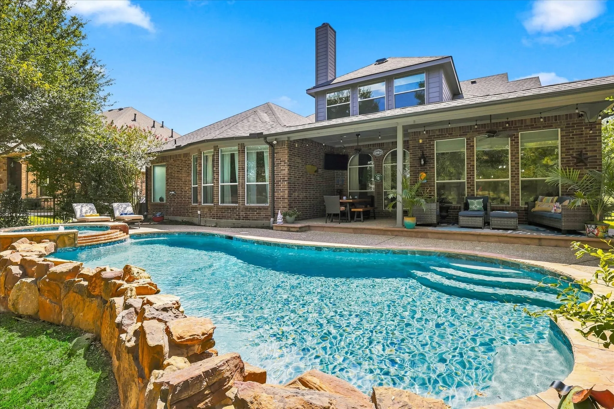 This backyard was made to impress — pool, spa, covered patio, and multiple spaces to lounge, entertain, and unwind.