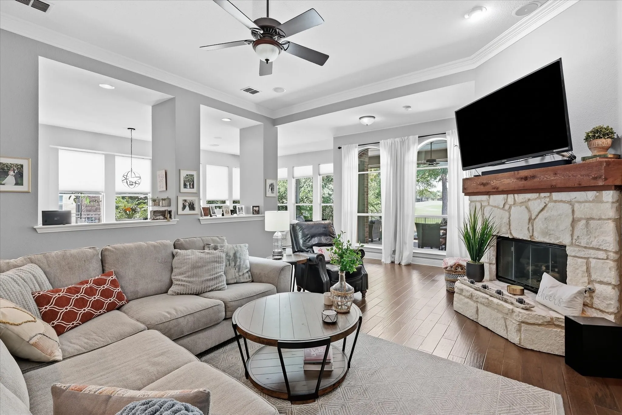Cozy meets sophisticated with warm hardwood floors, abundant natural light, and a beautiful stone fireplace anchoring the family room.