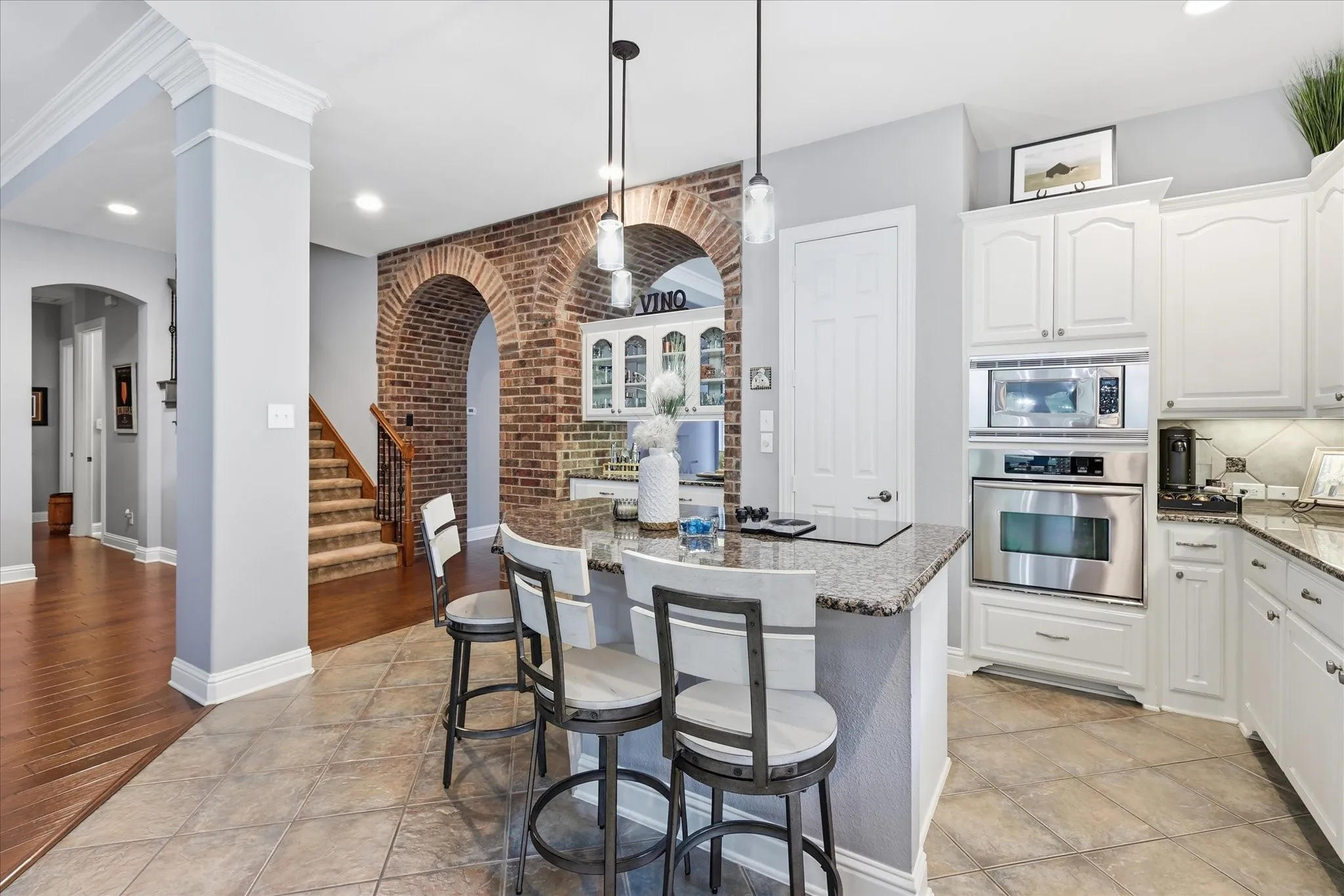 Character around every corner — the kitchen blends beautifully with the home’s warm brick architecture, hardwood floors, and open living spaces.