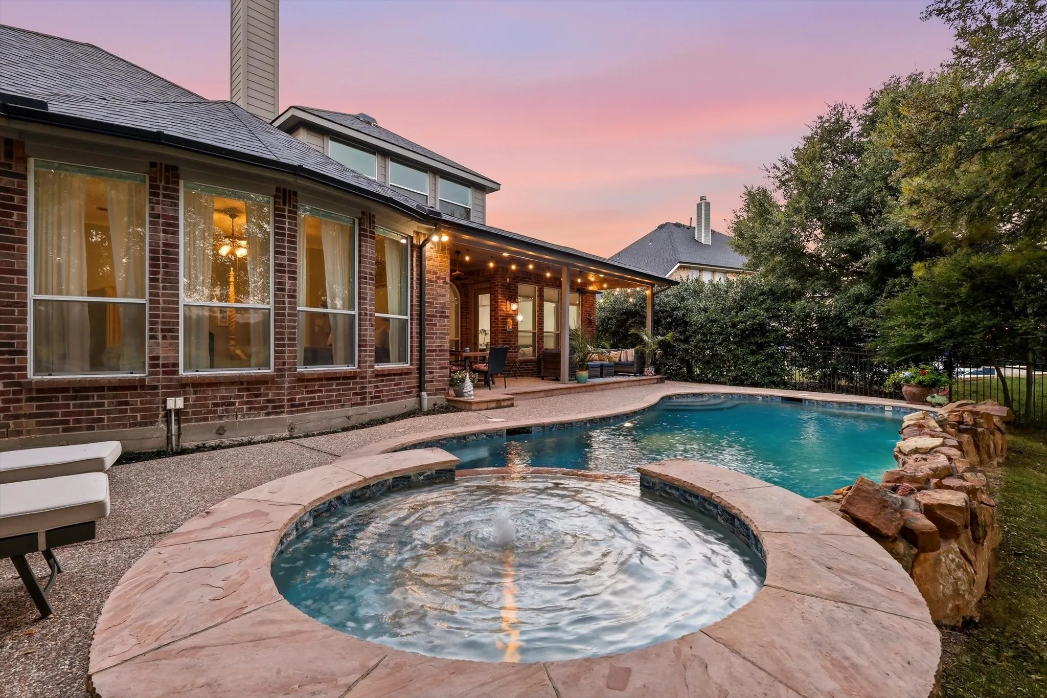 Evenings feel like a getaway in this incredible backyard, where the pool, spa, and covered patio create a resort-inspired escape overlooking the golf course. .