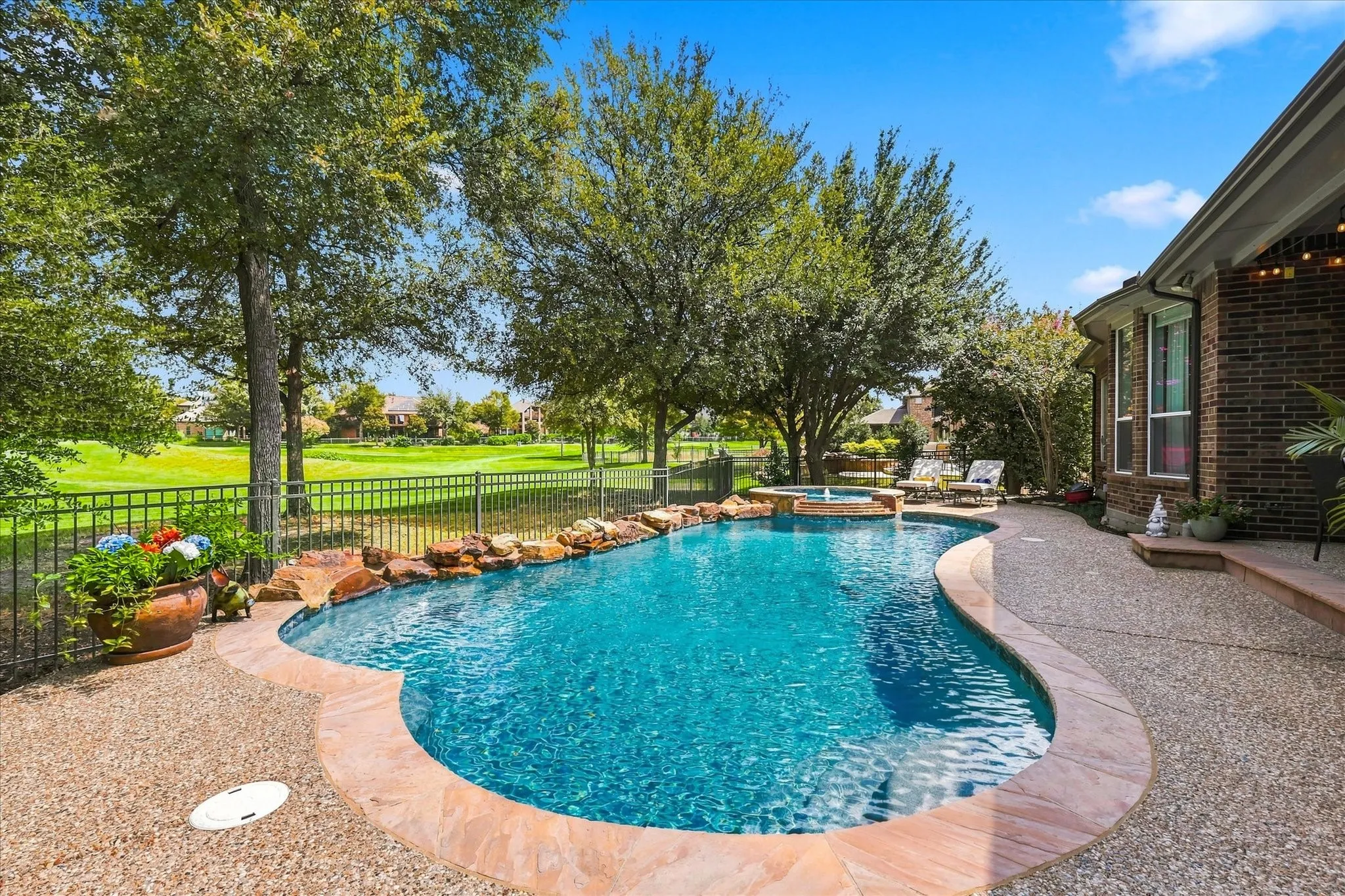 Resort-style backyard living begins here with a sparkling pool, spa, lush landscaping and peaceful golf course views beyond.