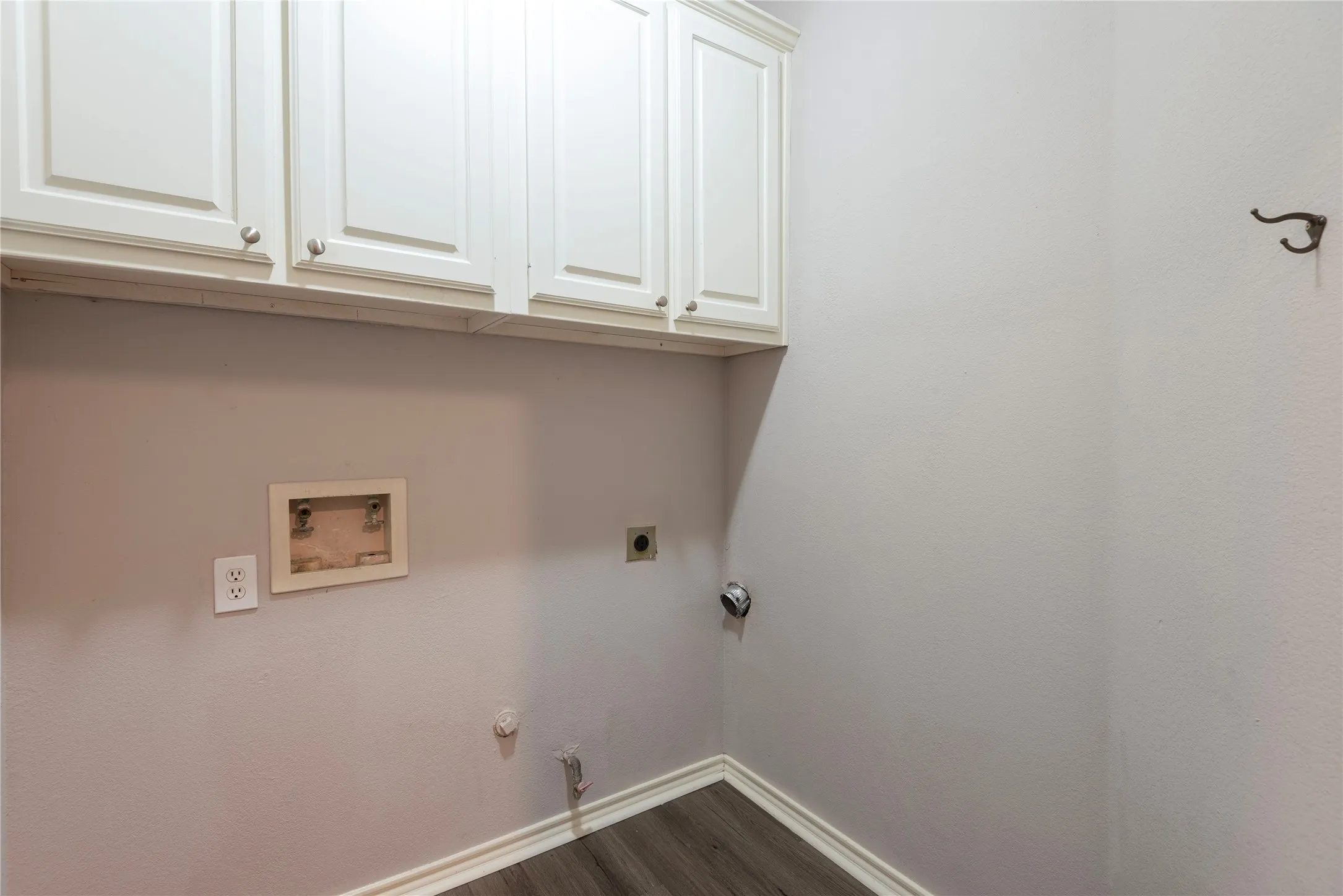 Clothes washing area with electric dryer hookup, cabinets, gas dryer hookup, dark wood-type flooring, and hookup for a washing machine