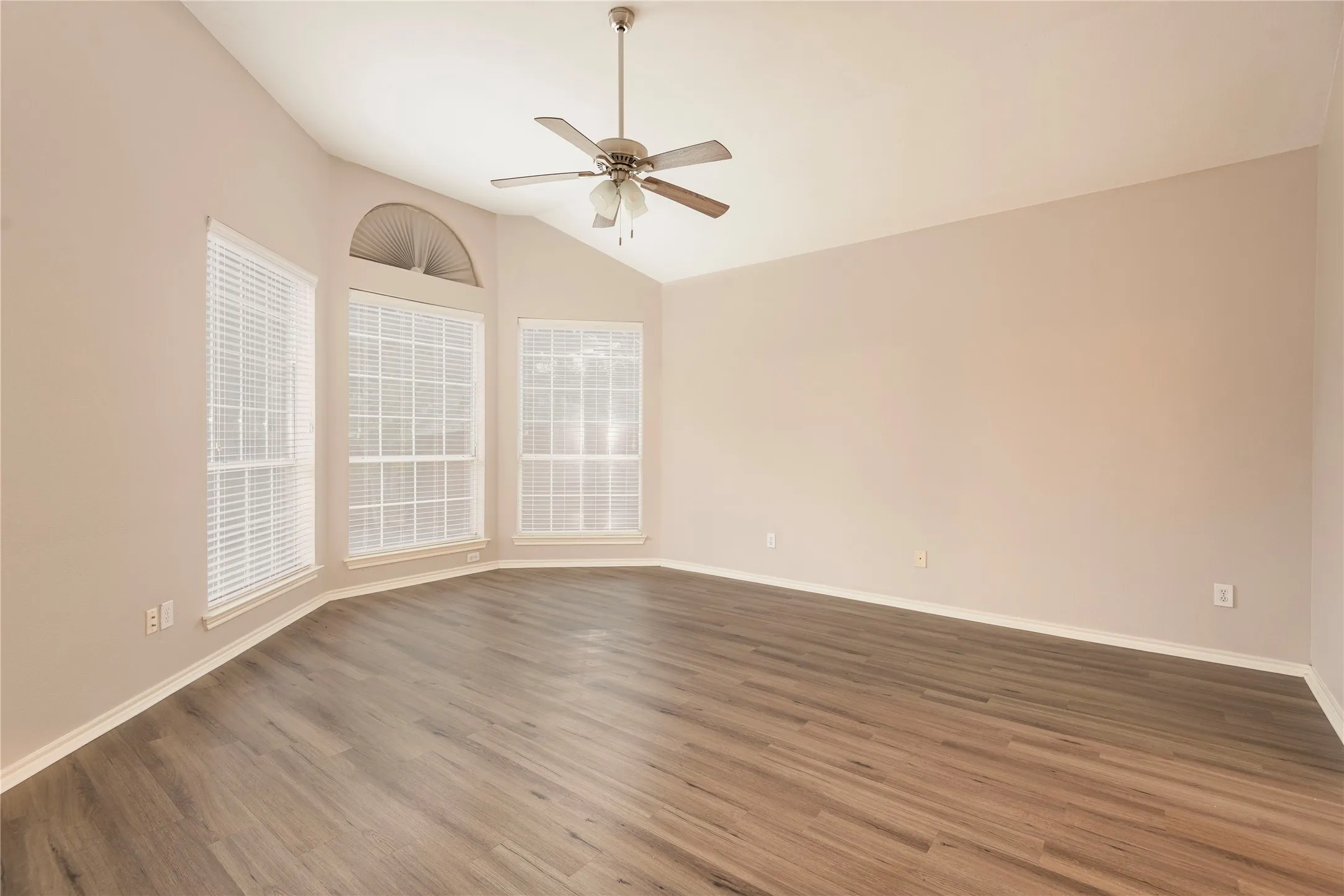 Spare room featuring ceiling fan, dark wood-type flooring, and vaulted ceiling