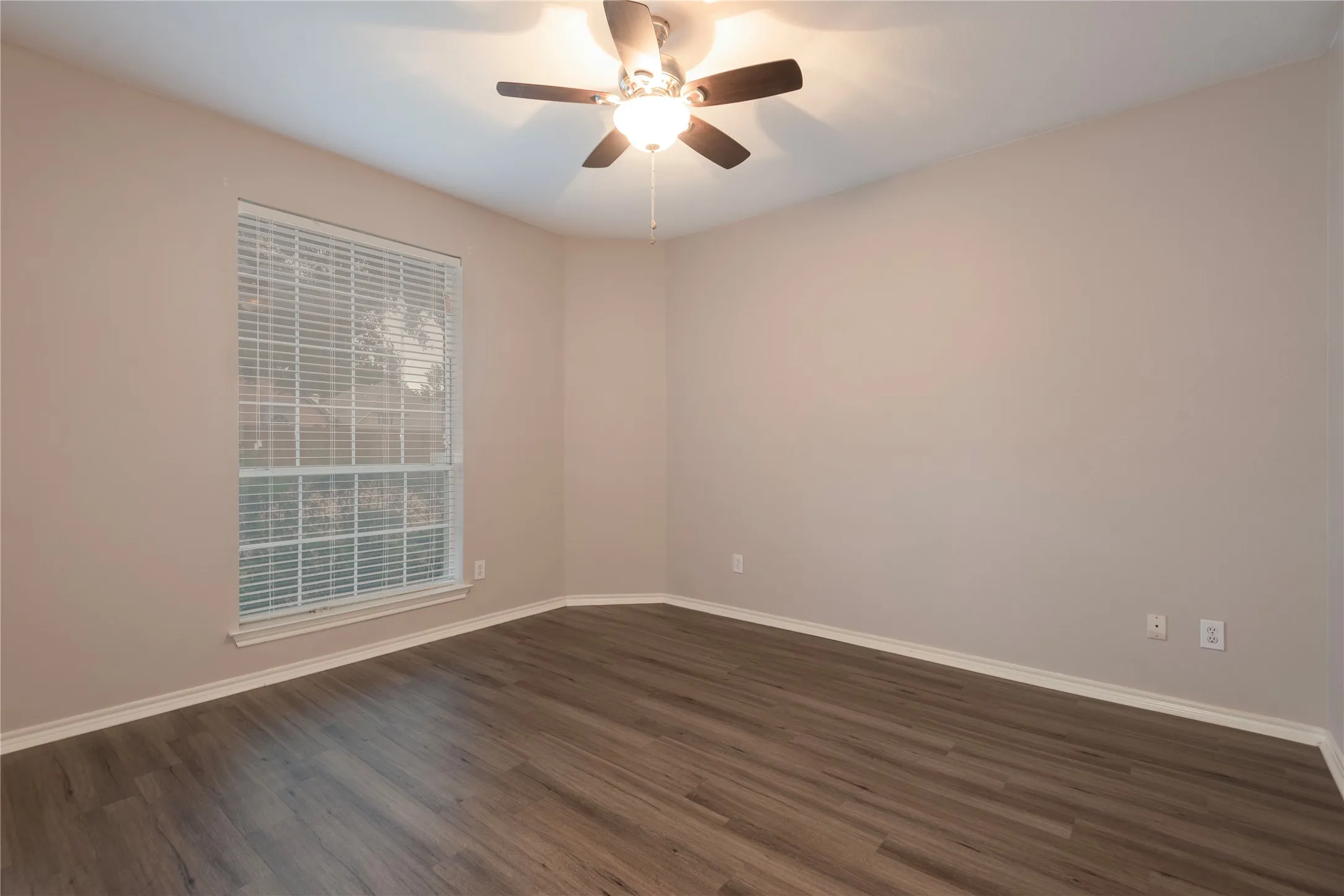 Unfurnished room featuring ceiling fan and dark wood-type flooring