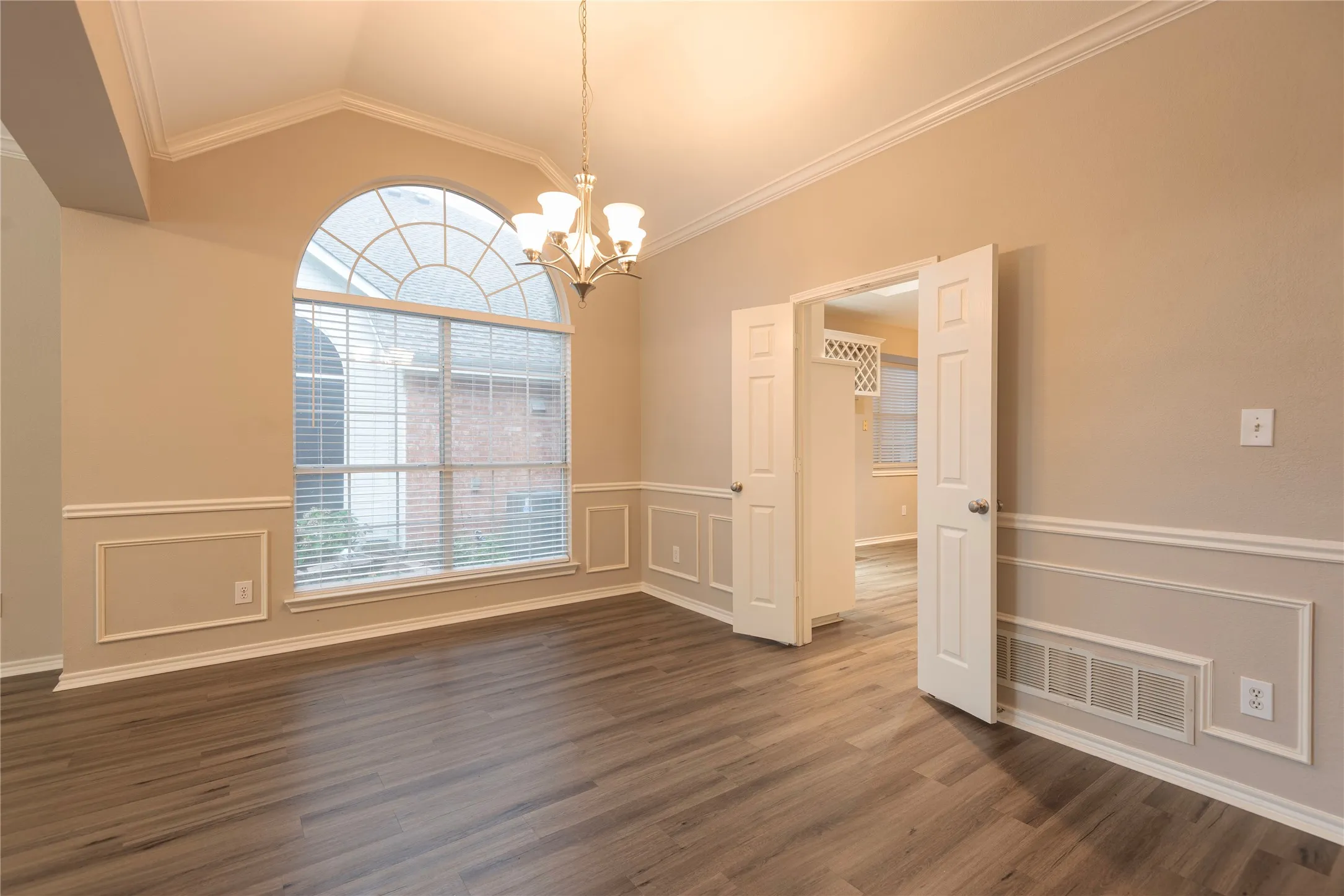 Unfurnished dining area with dark hardwood / wood-style flooring, ornamental molding, and vaulted ceiling