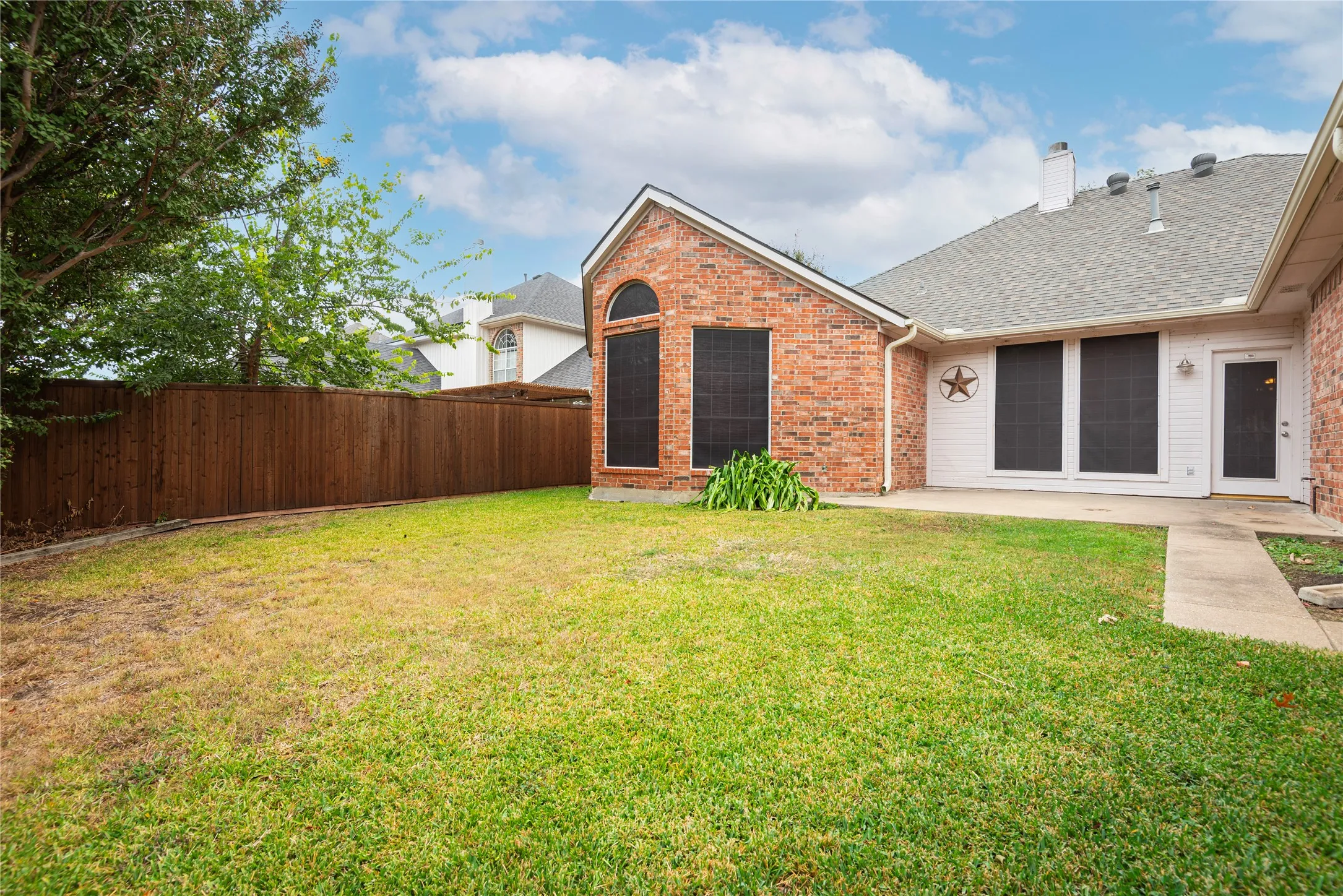 Rear view of house with a lawn and a patio