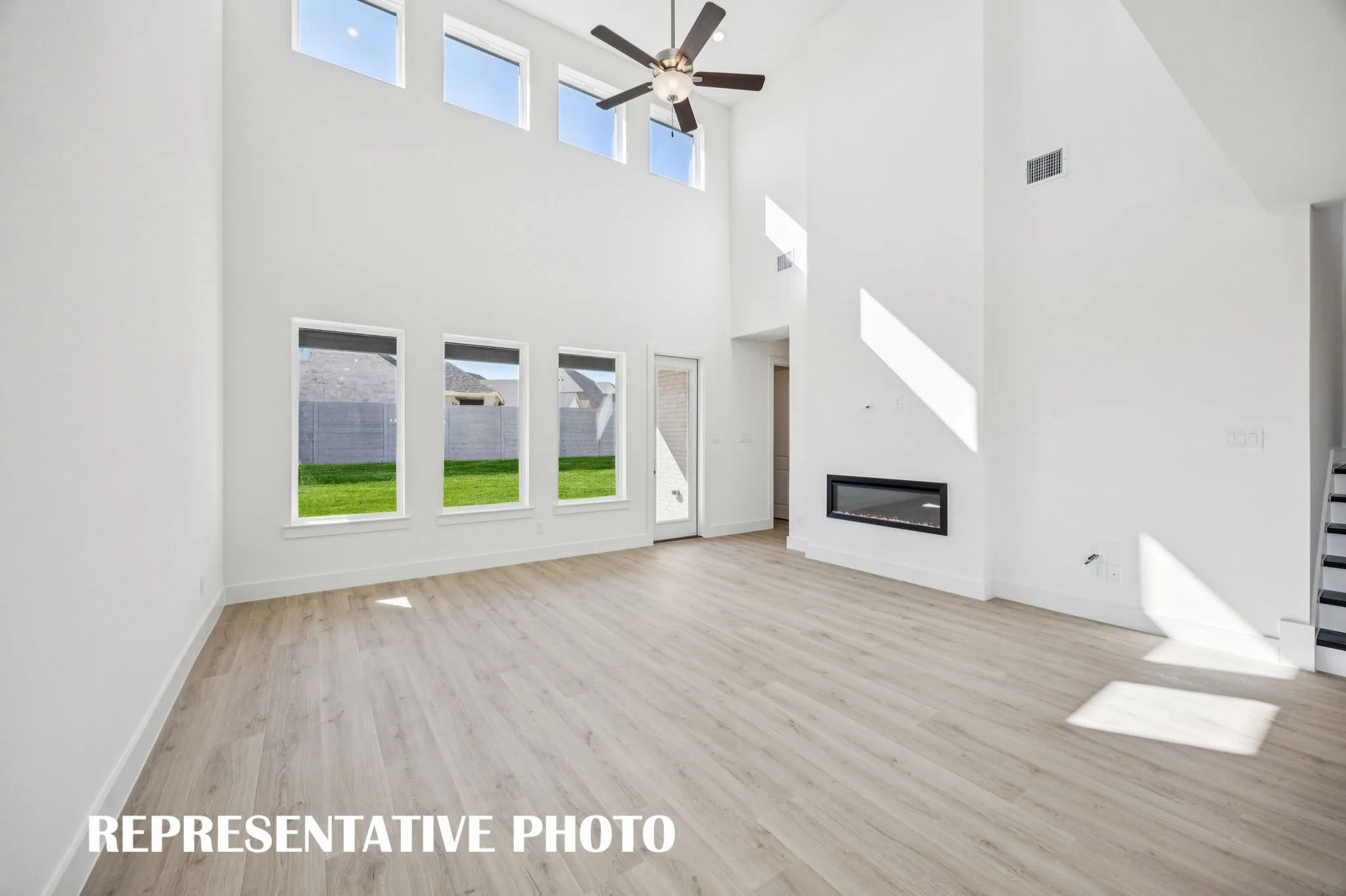 Your new family room is flooded with natural light from a dual stacked wall of windows! REPRESENTATIVE PHOTO