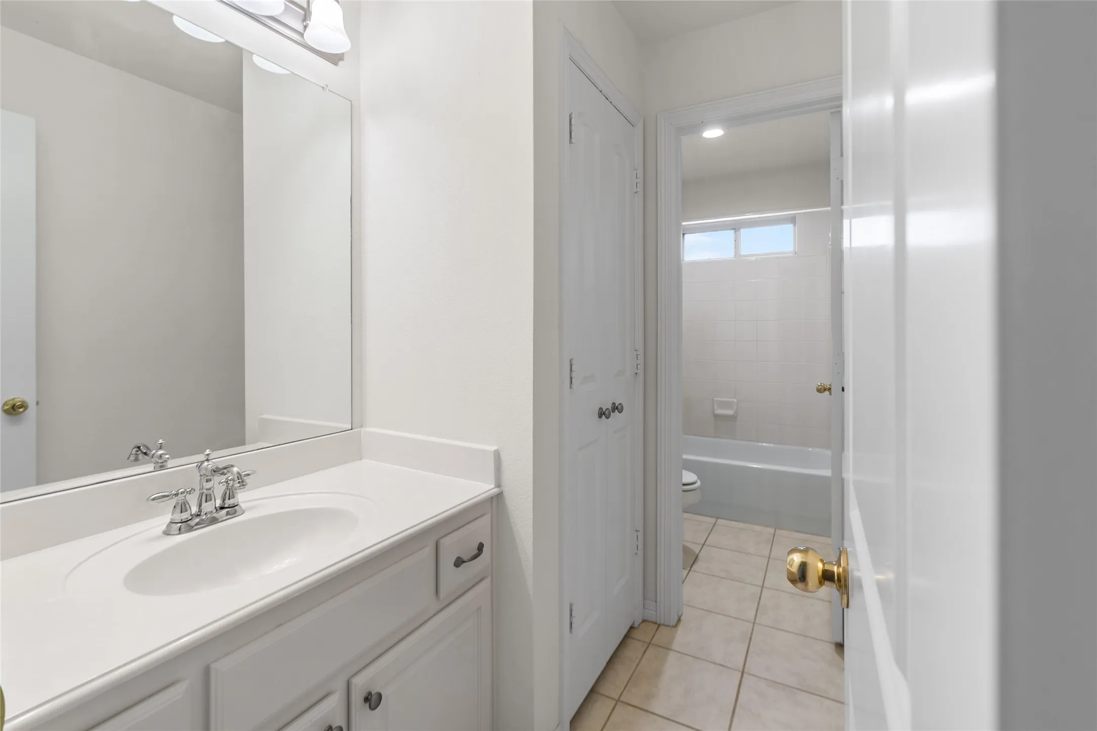 Bathroom vanity featuring an integrated sink, polished chrome faucet, and overhead lighting