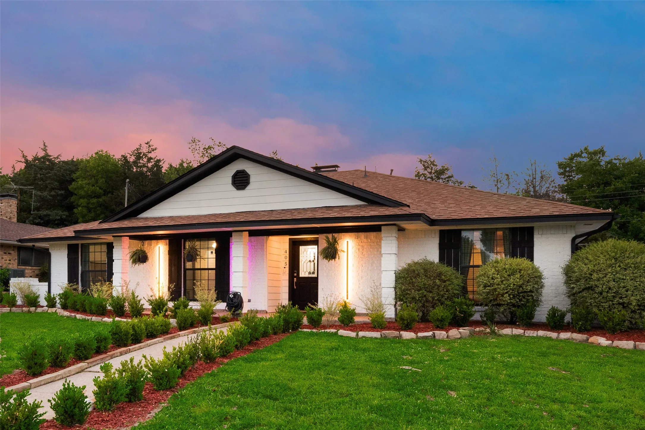 View of front of house featuring a front yard, roof with shingles, and brick siding