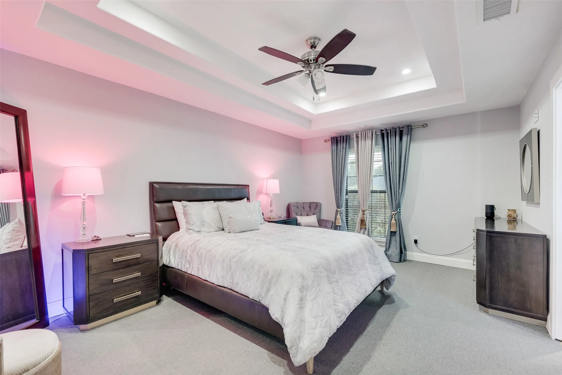 Bedroom featuring a raised ceiling, light colored carpet, a ceiling fan, and recessed lighting