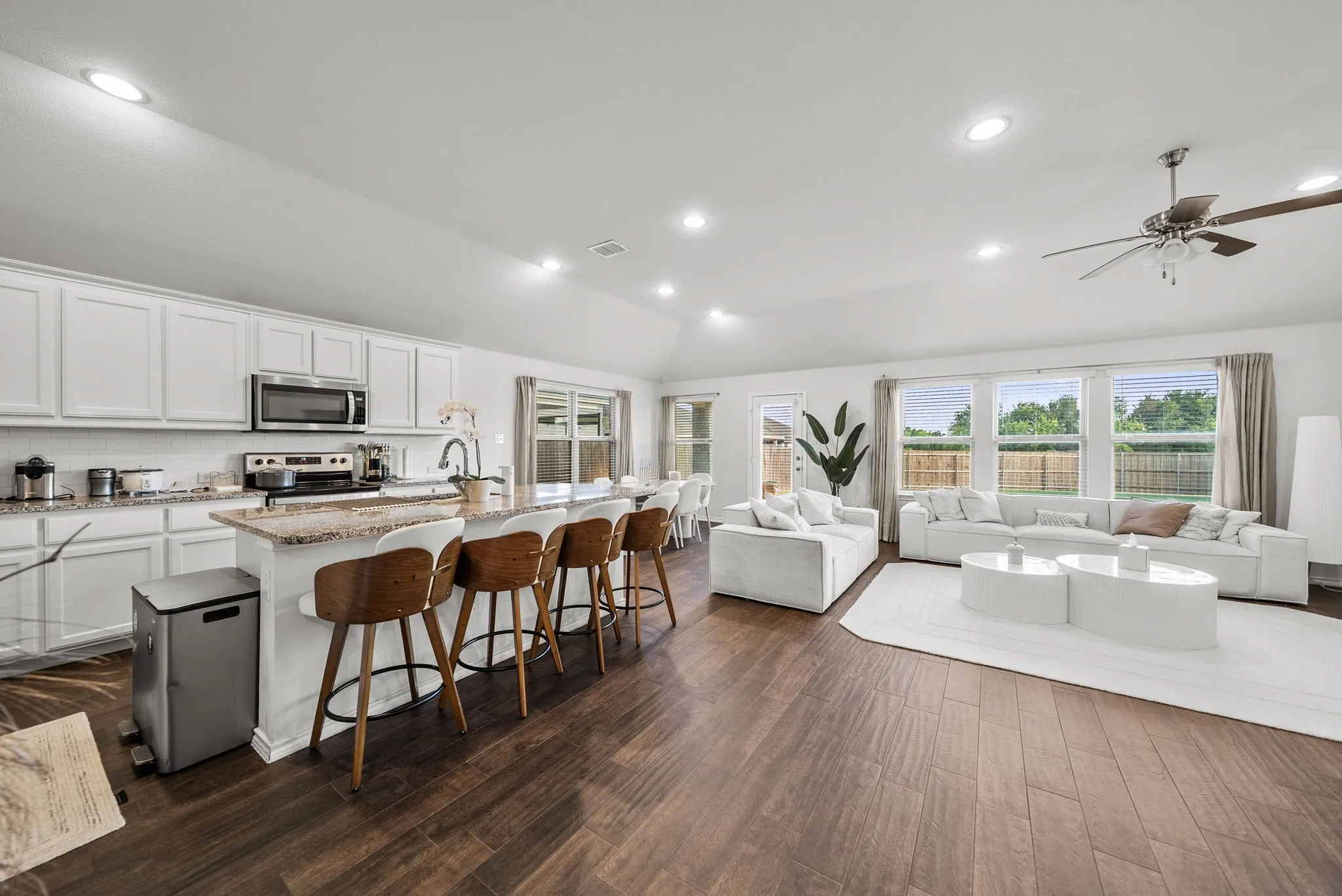 Open-concept living space featuring wood-finish flooring, recessed lighting, and a ceiling fan