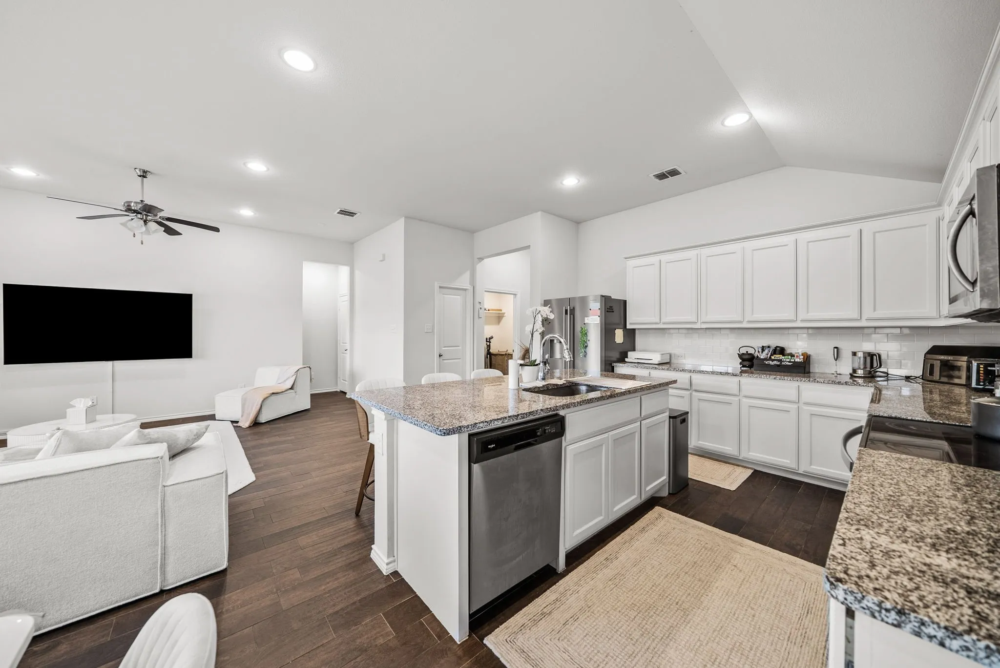 Kitchen island with a granite countertop, undermount sink, and stainless steel dishwasher