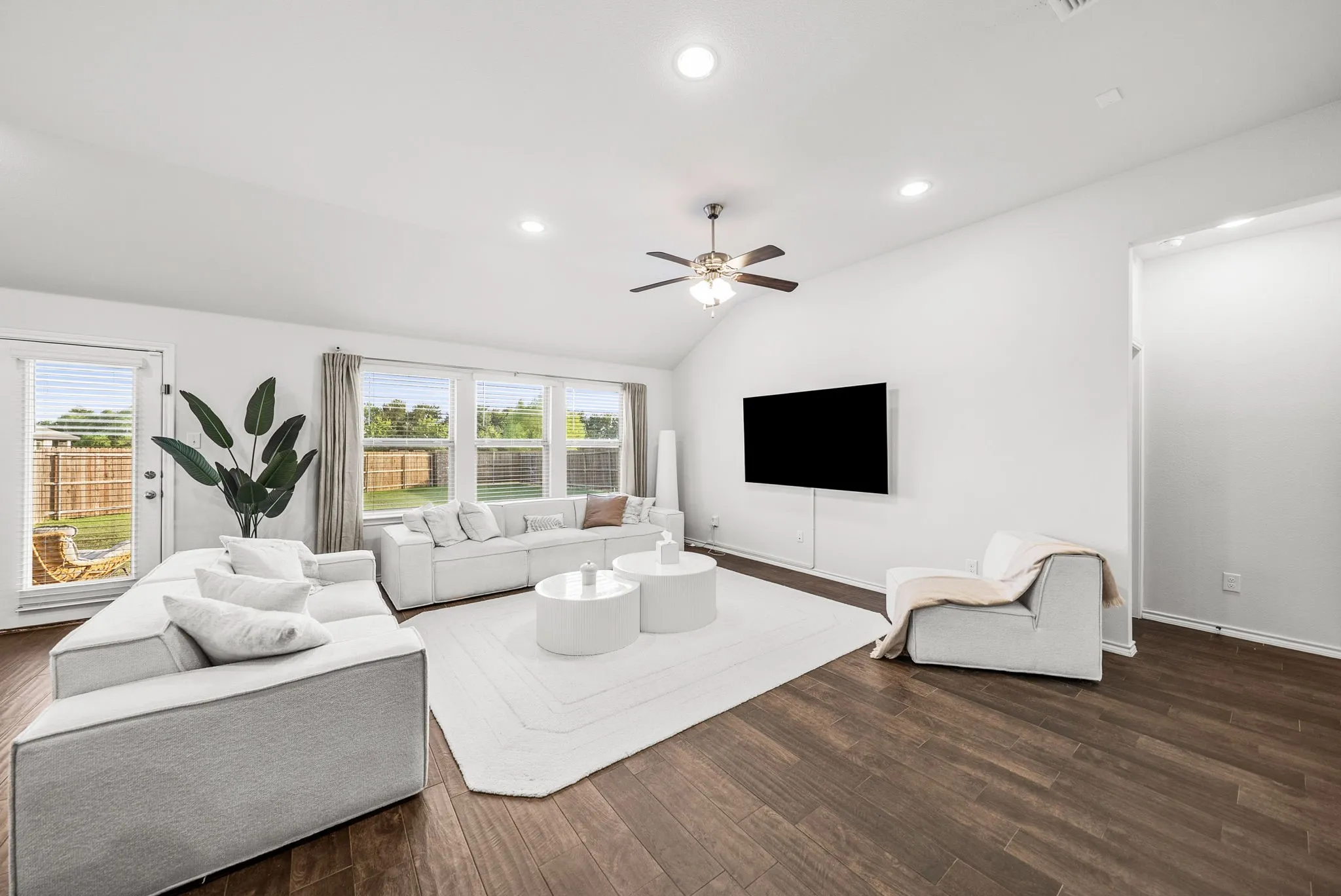 Vaulted ceiling, recessed lighting, wood-finish flooring, ceiling fan, and multiple windows