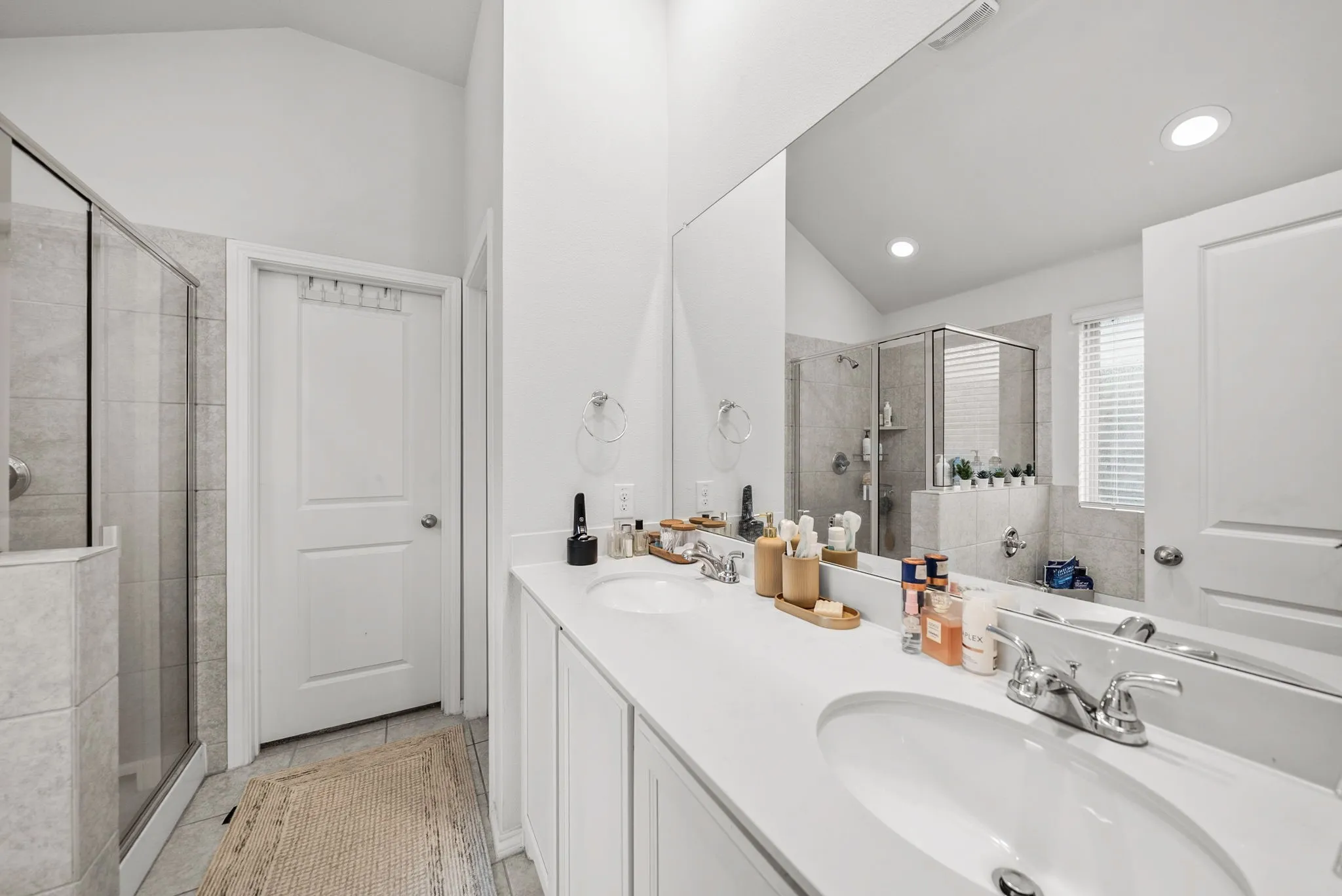 Dual vanity with undermount sinks, stone countertops, and chrome fixtures