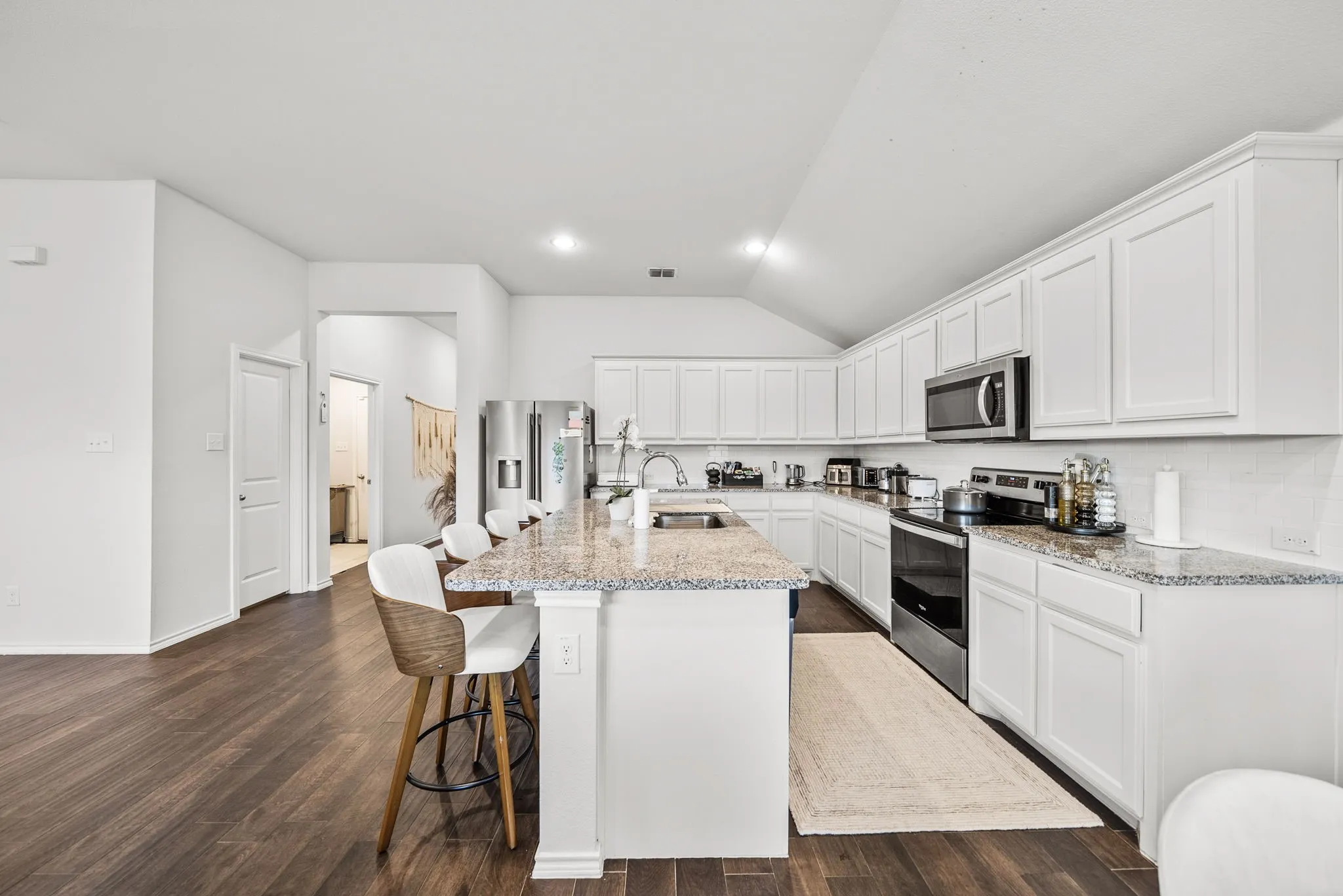 Kitchen featuring a central island with countertop, extensive white cabinetry, and stainless steel appliances