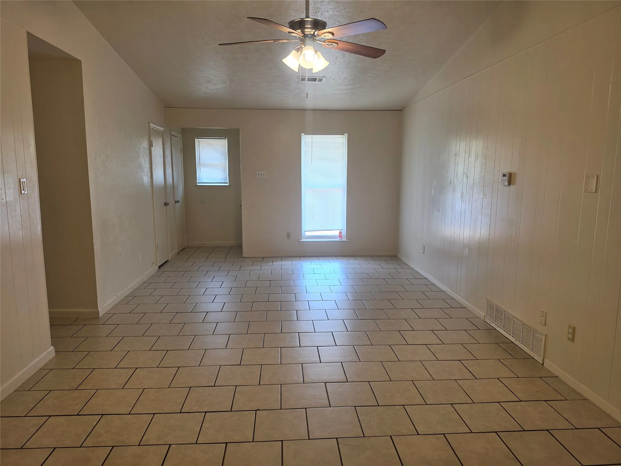 Recessed lighting, ceiling fan, tile flooring, two pane windows, vertical paneling