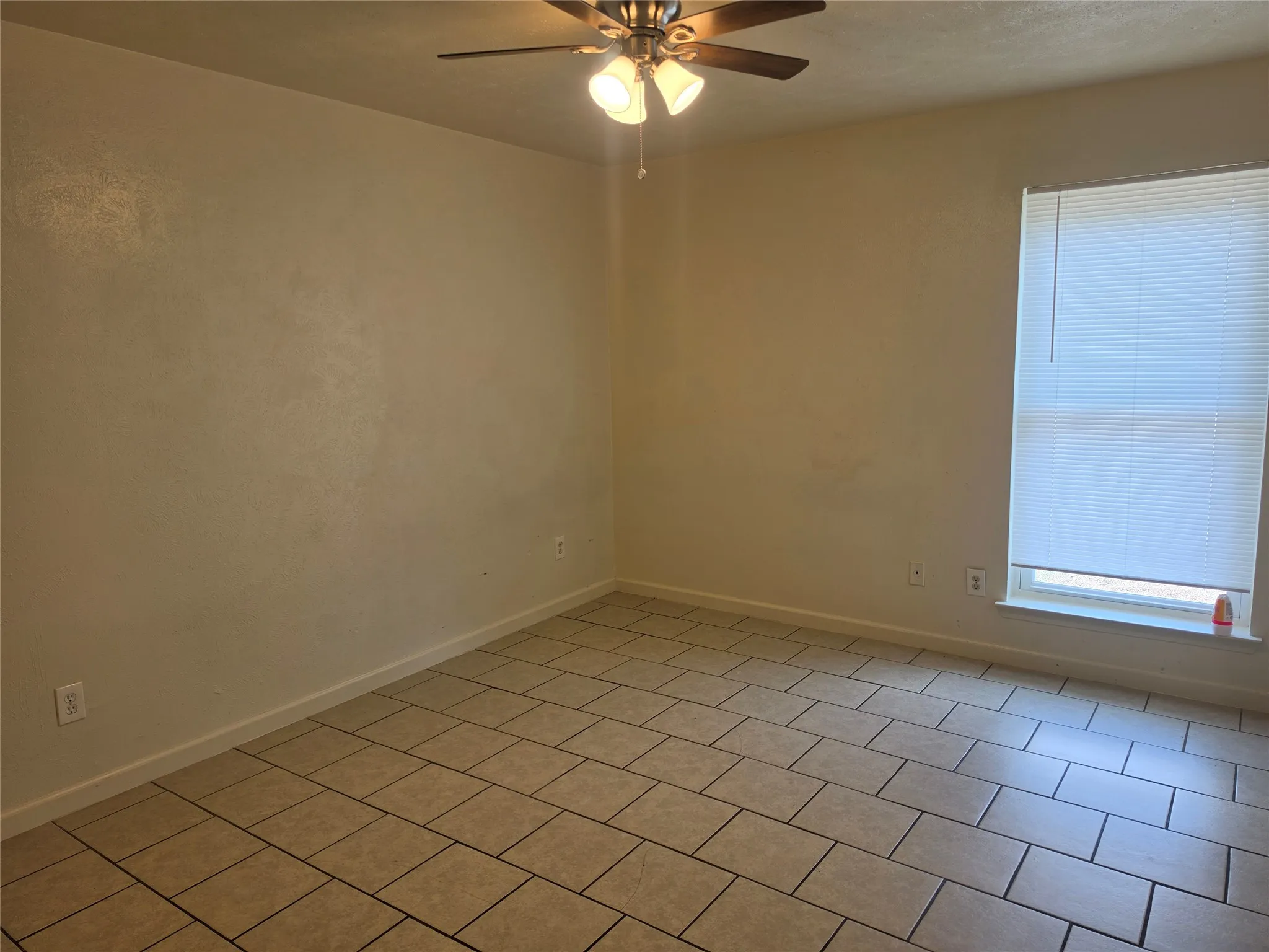 Ceiling fan with light fixture, tiled flooring, window with blinds, and neutral wall tones