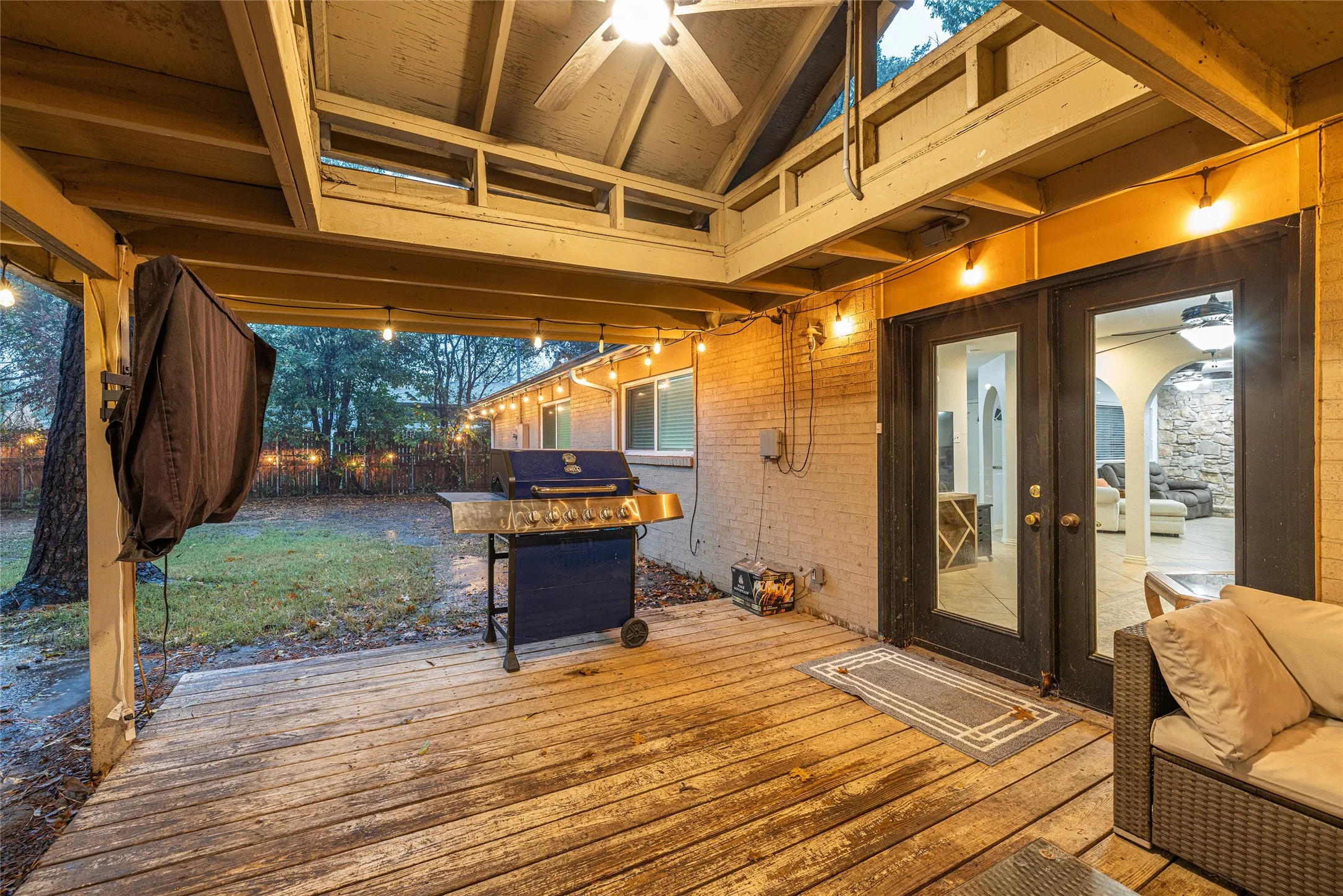 Covered wood-finish deck with string lighting and ceiling fan