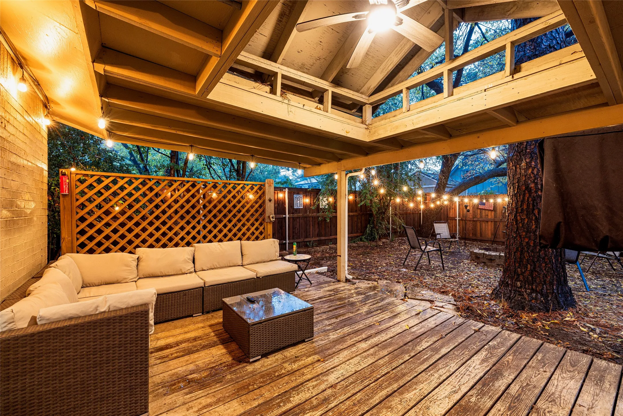 Covered outdoor deck with exposed wood rafters and a ceiling fan