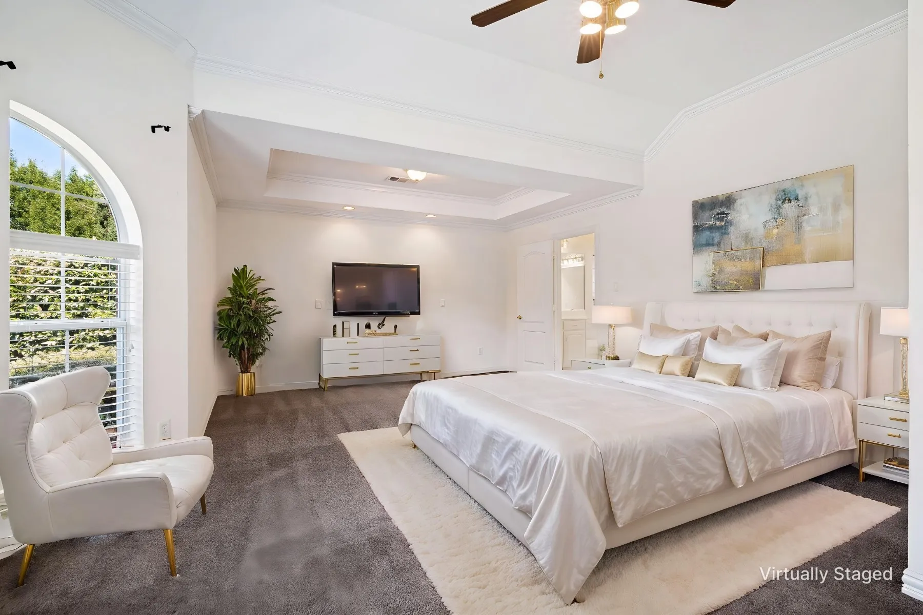The spacious primary suite has lots of natural light for a reading area, a beautiful tray ceiling and is split from the other bedrooms for privacy.