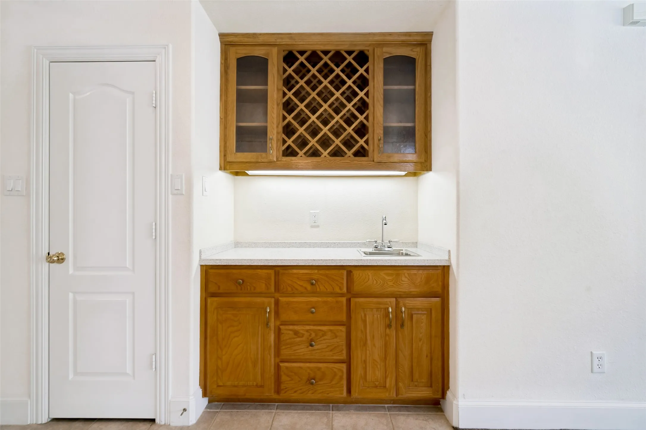 The wet bar features a sink, storage cabinets and a hutch with a wine rack. Perfect for entertaining.