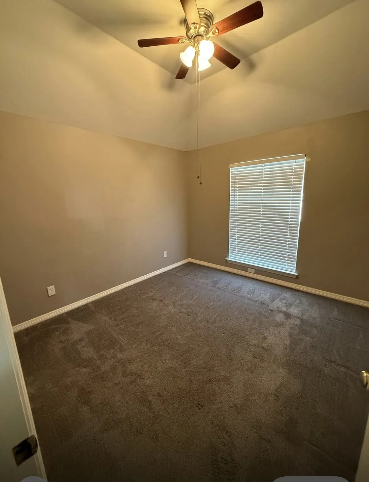 Spare room with lofted ceiling, dark carpet, and ceiling fan