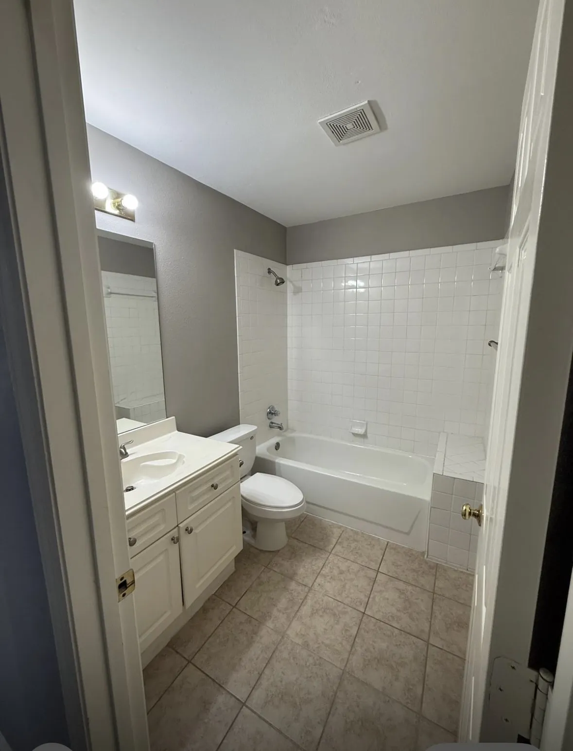 Full bathroom featuring vanity, toilet, tile patterned floors, and tiled shower / bath