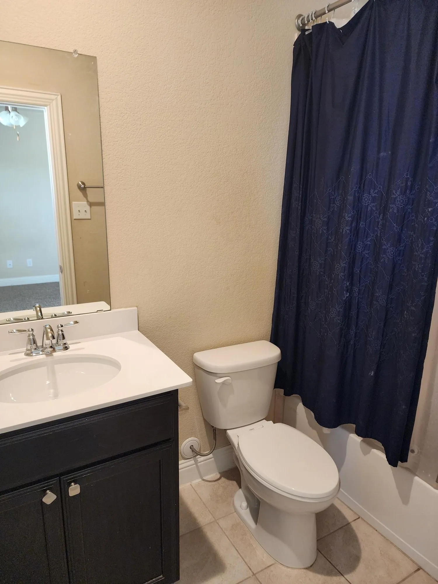 Contemporary bathroom featuring a dark wood vanity with white porcelain sink, chrome faucet fixtures, and ample mirror