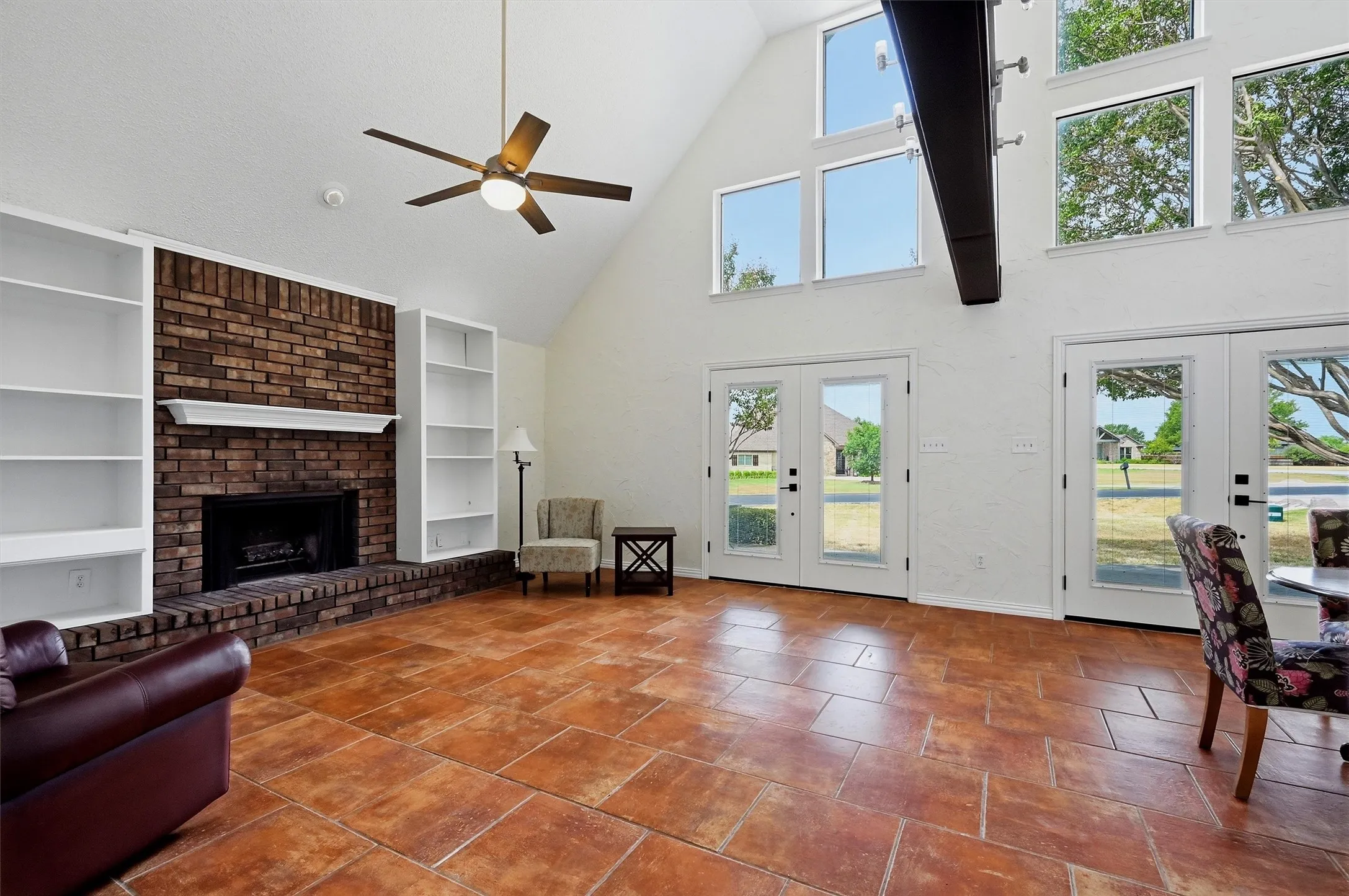 Vaulted ceilings, multiple large windows, and terra cotta-style tile flooring