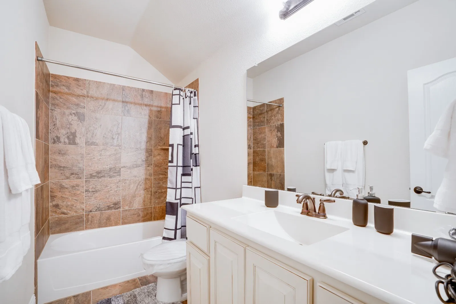Single vanity with an integrated sink, white countertop, and oil-rubbed bronze faucet