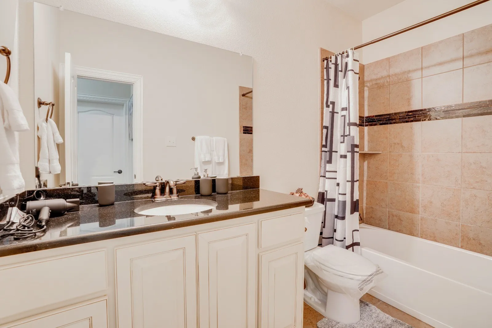 Vanity with an integrated sink, dark countertop, and brushed nickel faucet