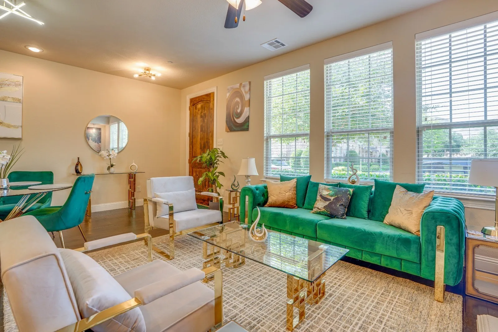 Three large windows with blinds, recessed lighting, ceiling fan, wood-finish flooring, and a paneled door