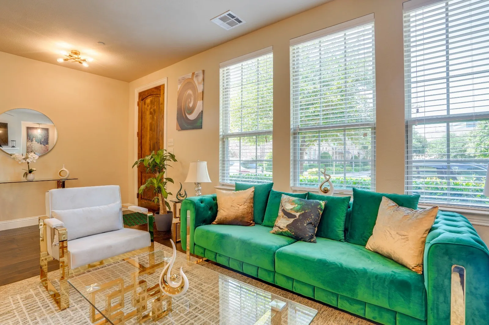 Hardwood-style flooring, multiple large windows with blinds, recessed ceiling light, and a wood-paneled door