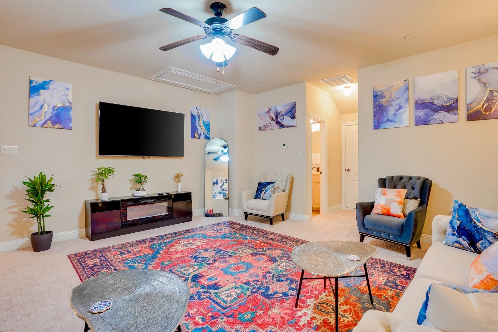 Carpeted living area featuring a ceiling fan, recessed lighting, and a built-in media console with an electric fireplace