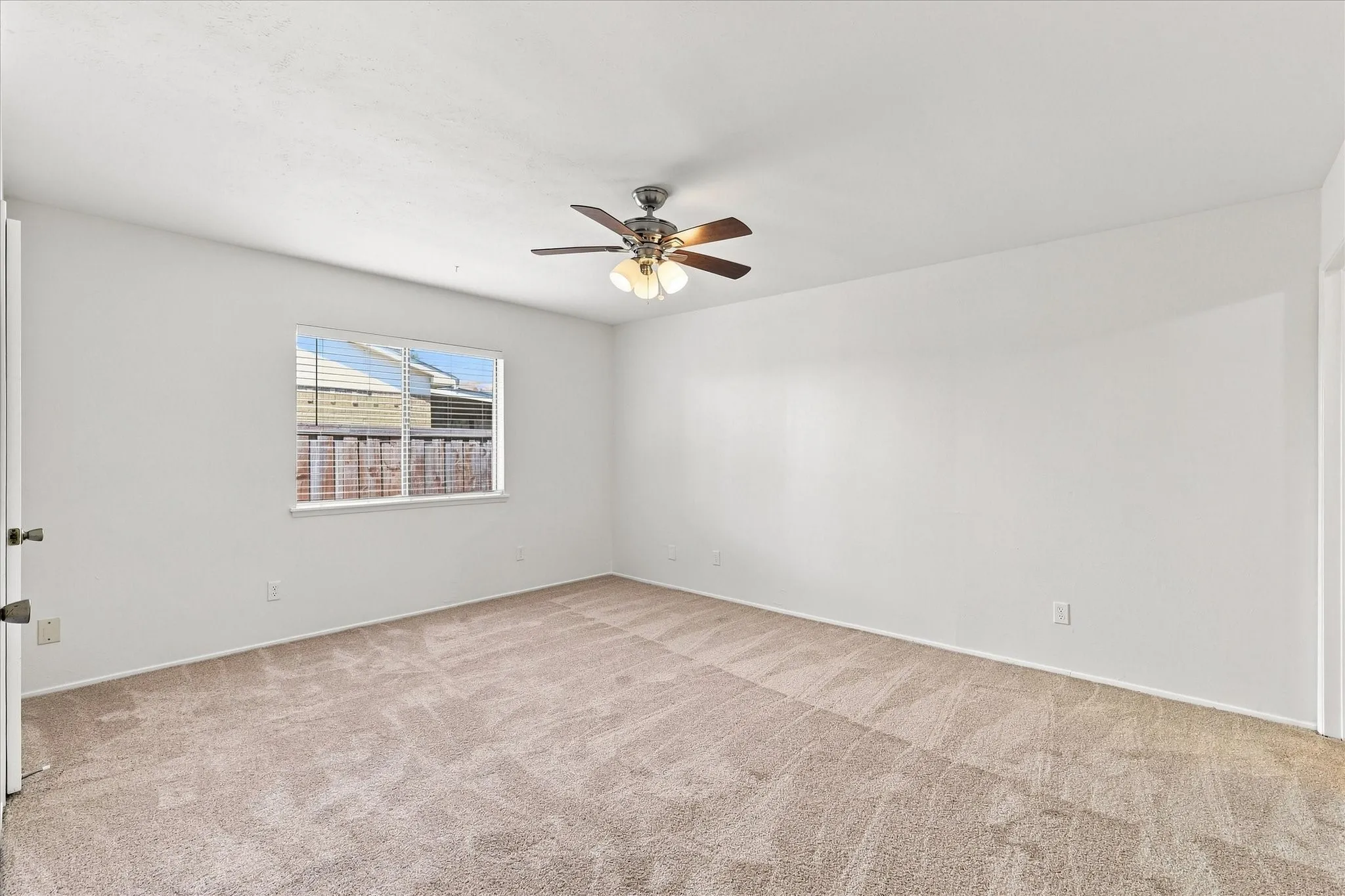 Spacious primary suite with ceiling fan, ensuite bathroom, and two walk-in closets
