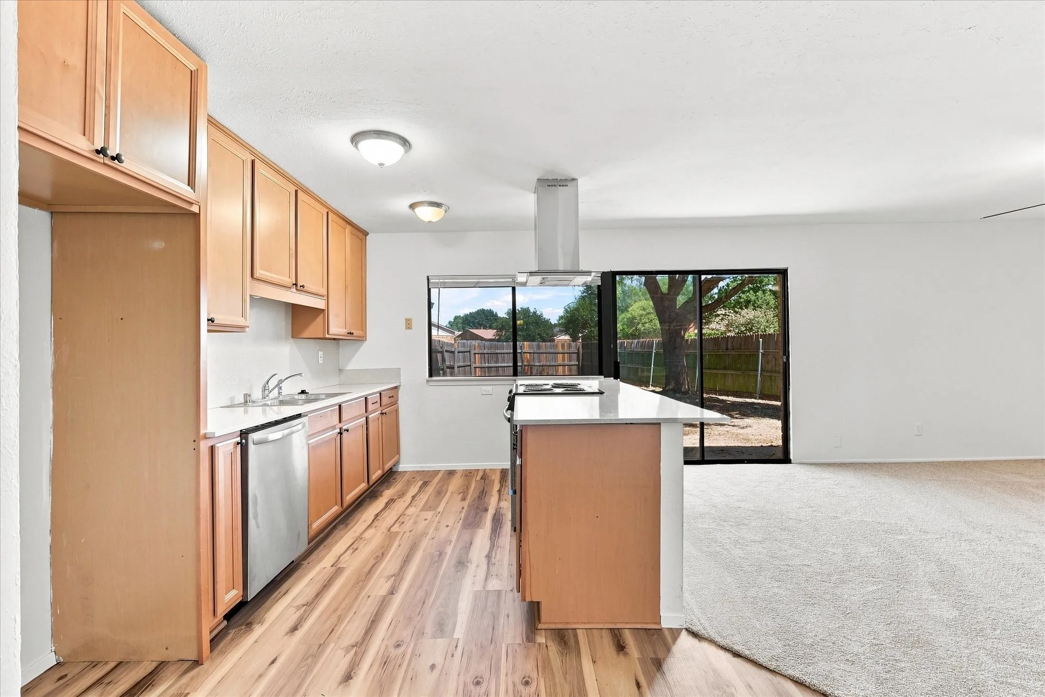 Generous custom cabinets, Corian counters, stainless steel appliances, and newly-installed LVP.