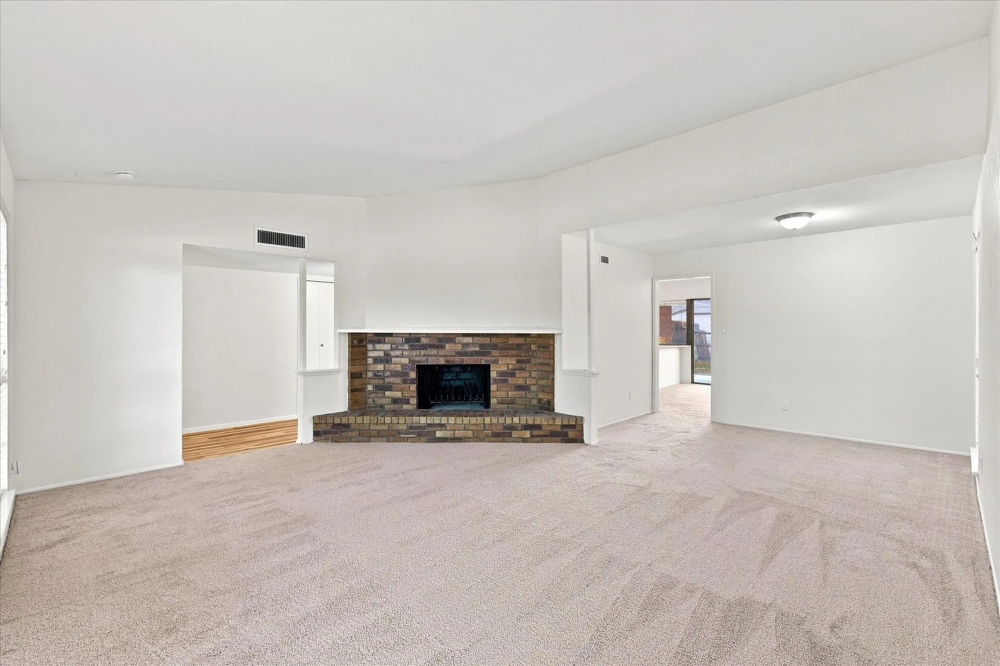 Spacious living area with tall ceilings and a cozy wood-burning fireplace.
