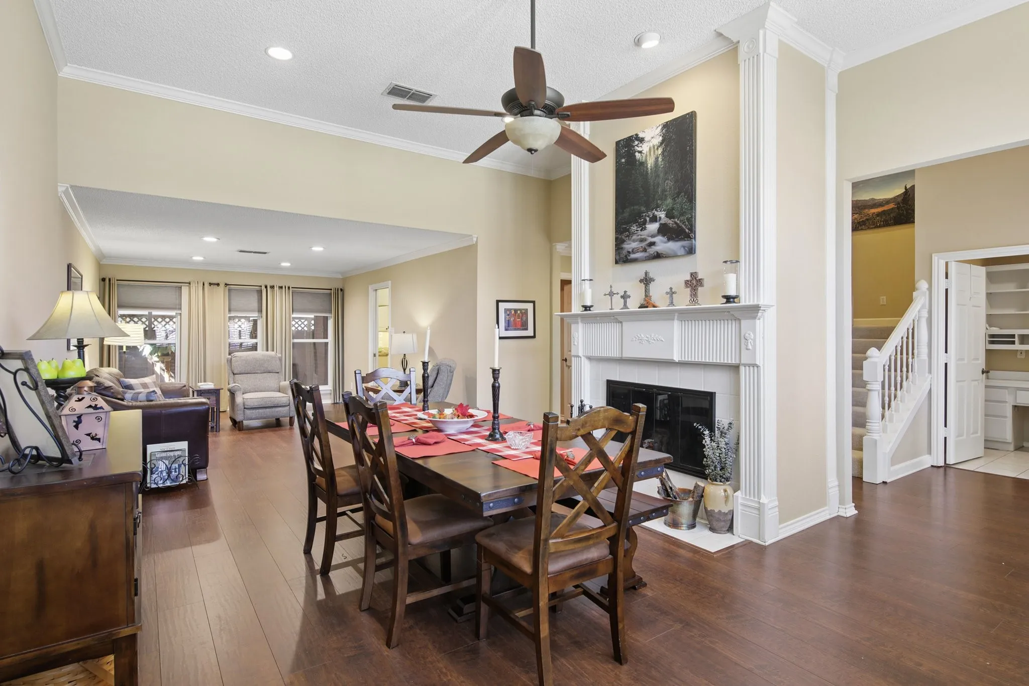 Spacious interior with vaulted ceilings, wood flooring, a built-in fireplace with a decorative mantel, and recessed lighting