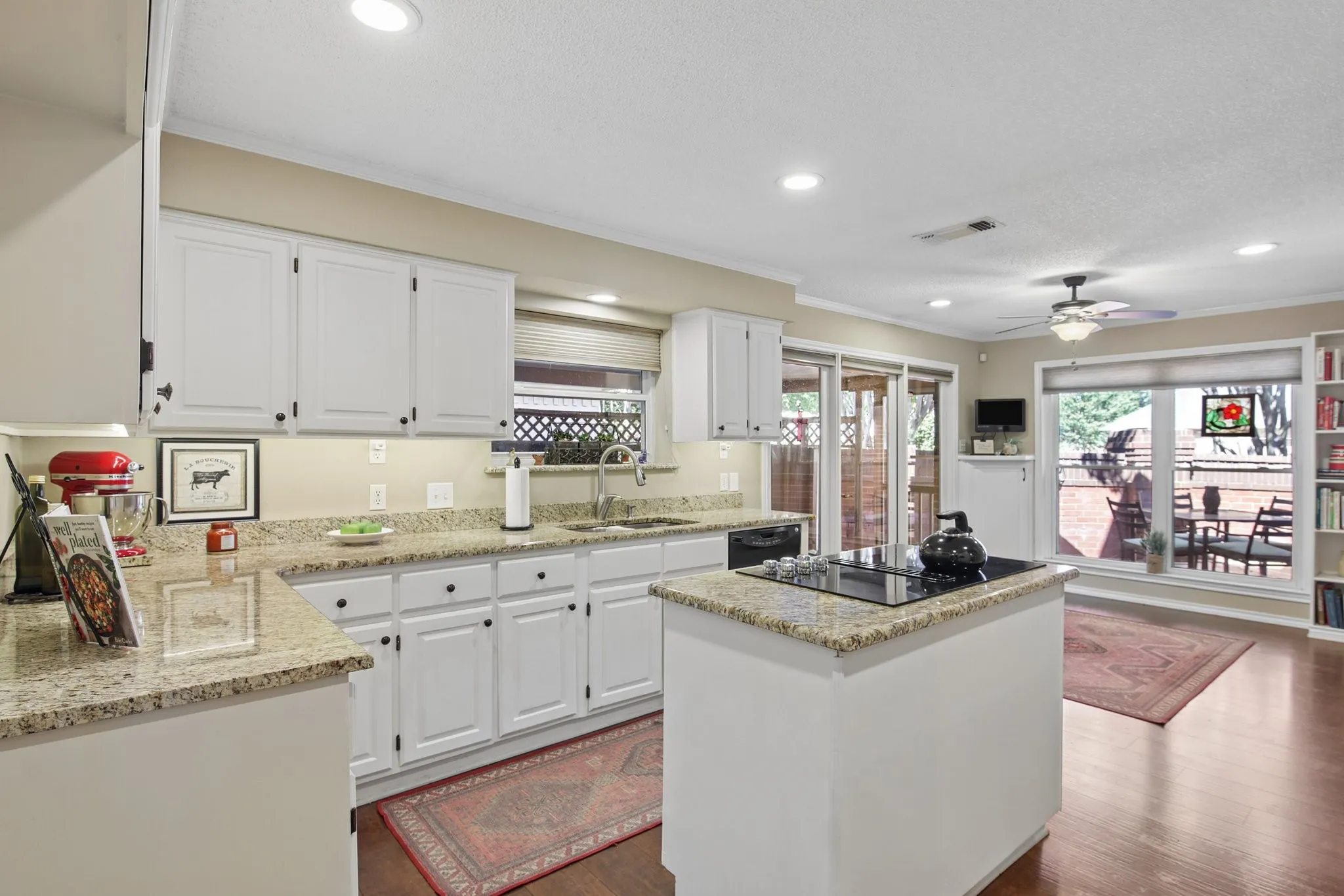 Kitchen featuring white shaker-style cabinetry, granite countertops, a center island with a built-in cooktop, recessed lighting, and wood-finish flooring
