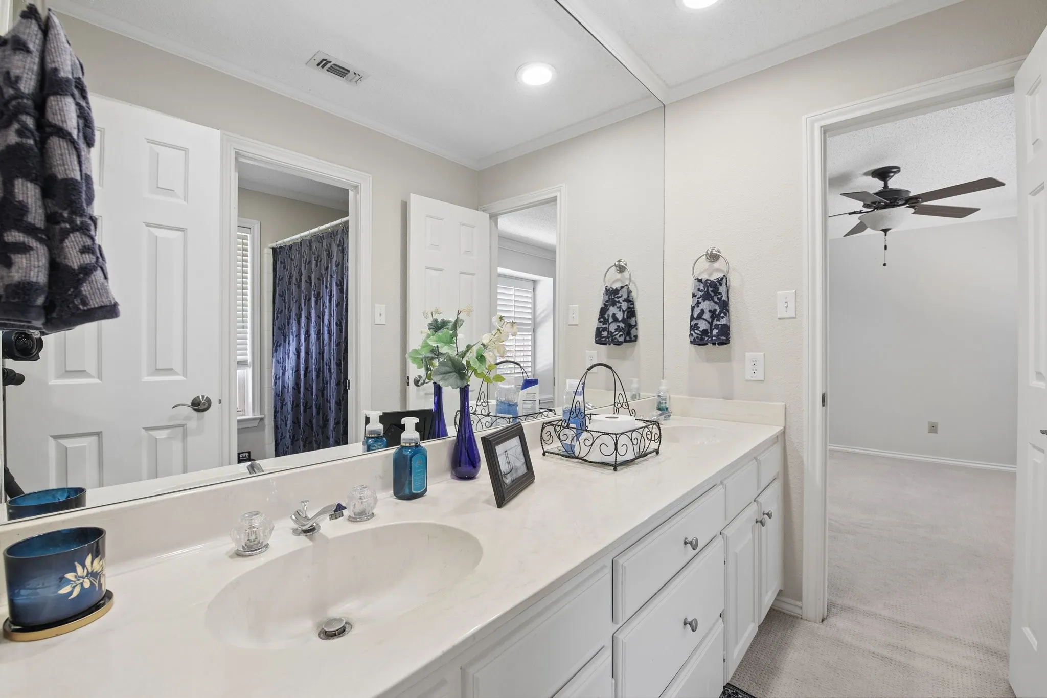 Bathroom vanity featuring an integrated sink, polished chrome faucet, and ample under-counter storage
