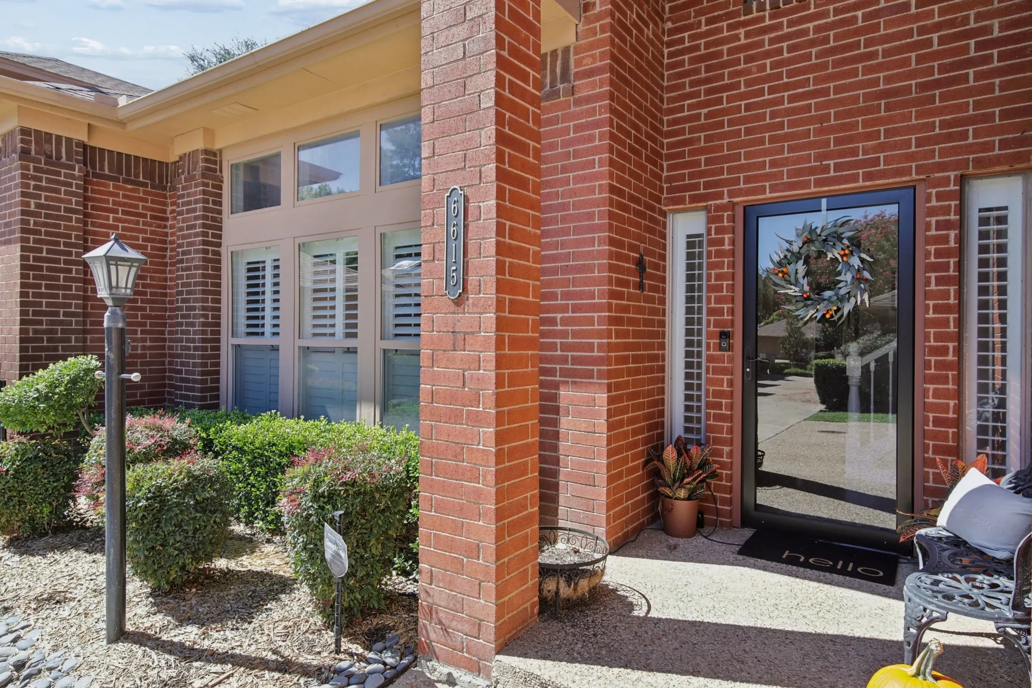 Brick exterior with a glass-paneled entry door, side lights, and transom windows