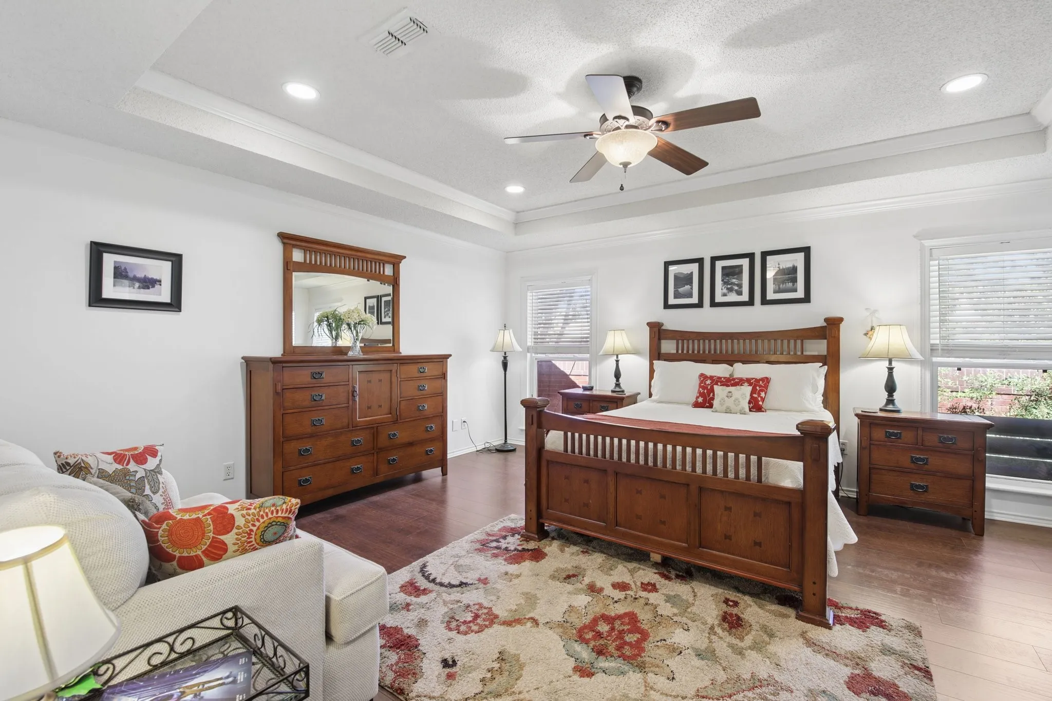 Tray ceiling with recessed lighting and crown molding, wood-finish flooring, and ceiling fan