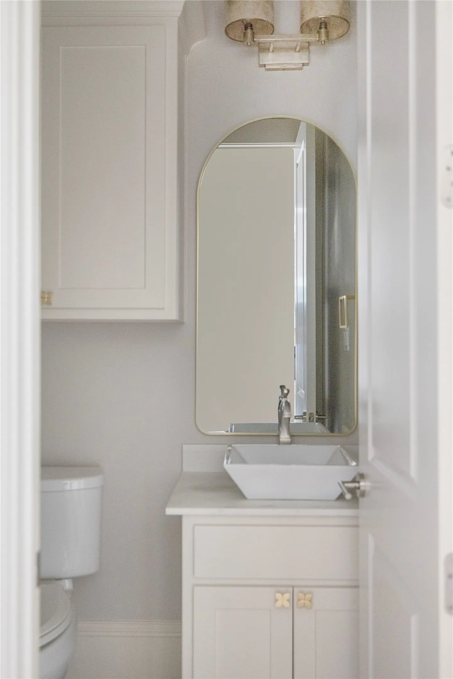 White shaker-style vanity with a vessel sink and single-handle faucet