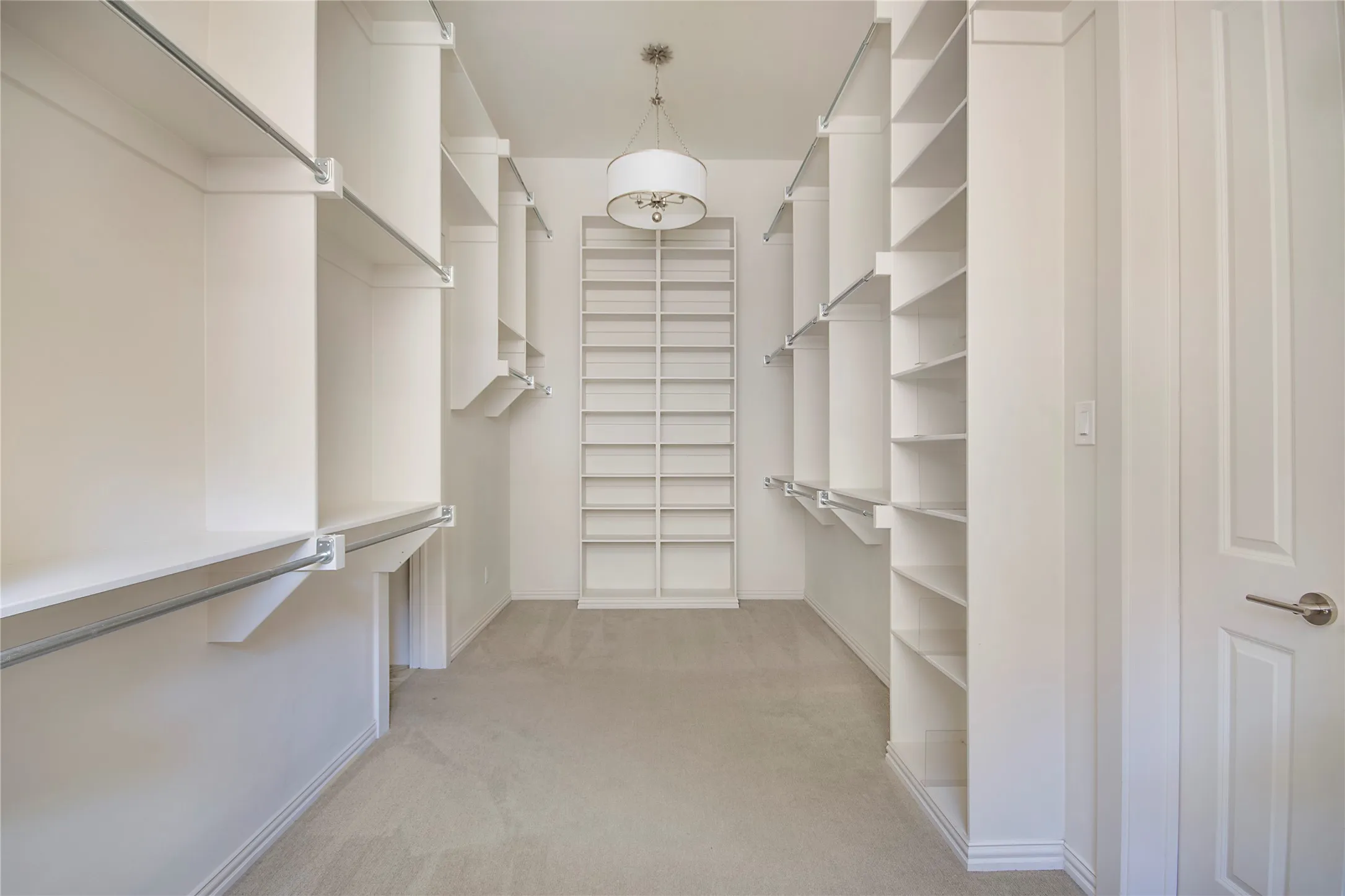 Walk-in closet featuring extensive built-in shelving, multiple hanging rods, recessed lighting, and carpet flooring
