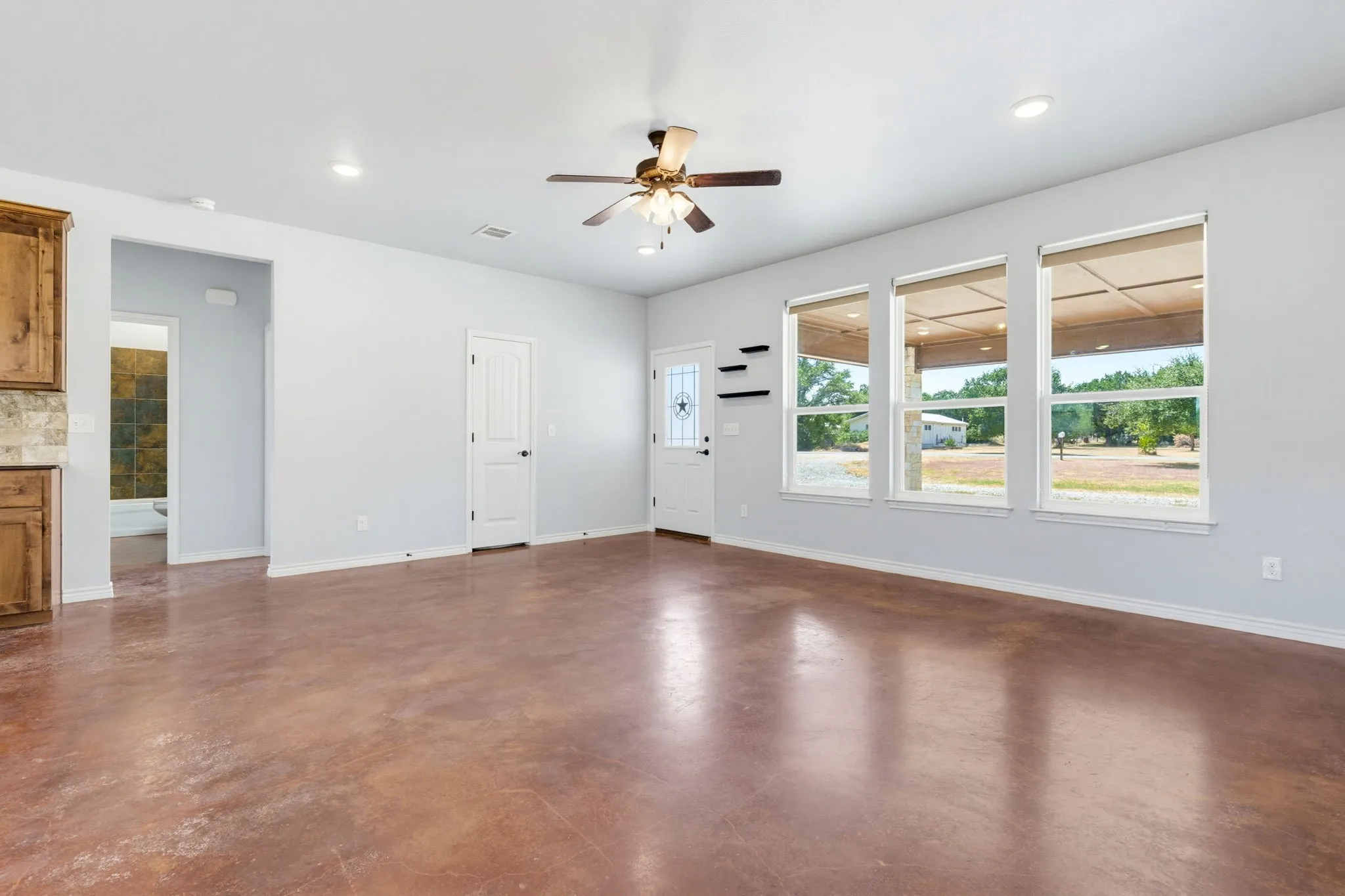 Expansive room featuring polished concrete flooring, recessed lighting, and a ceiling fan