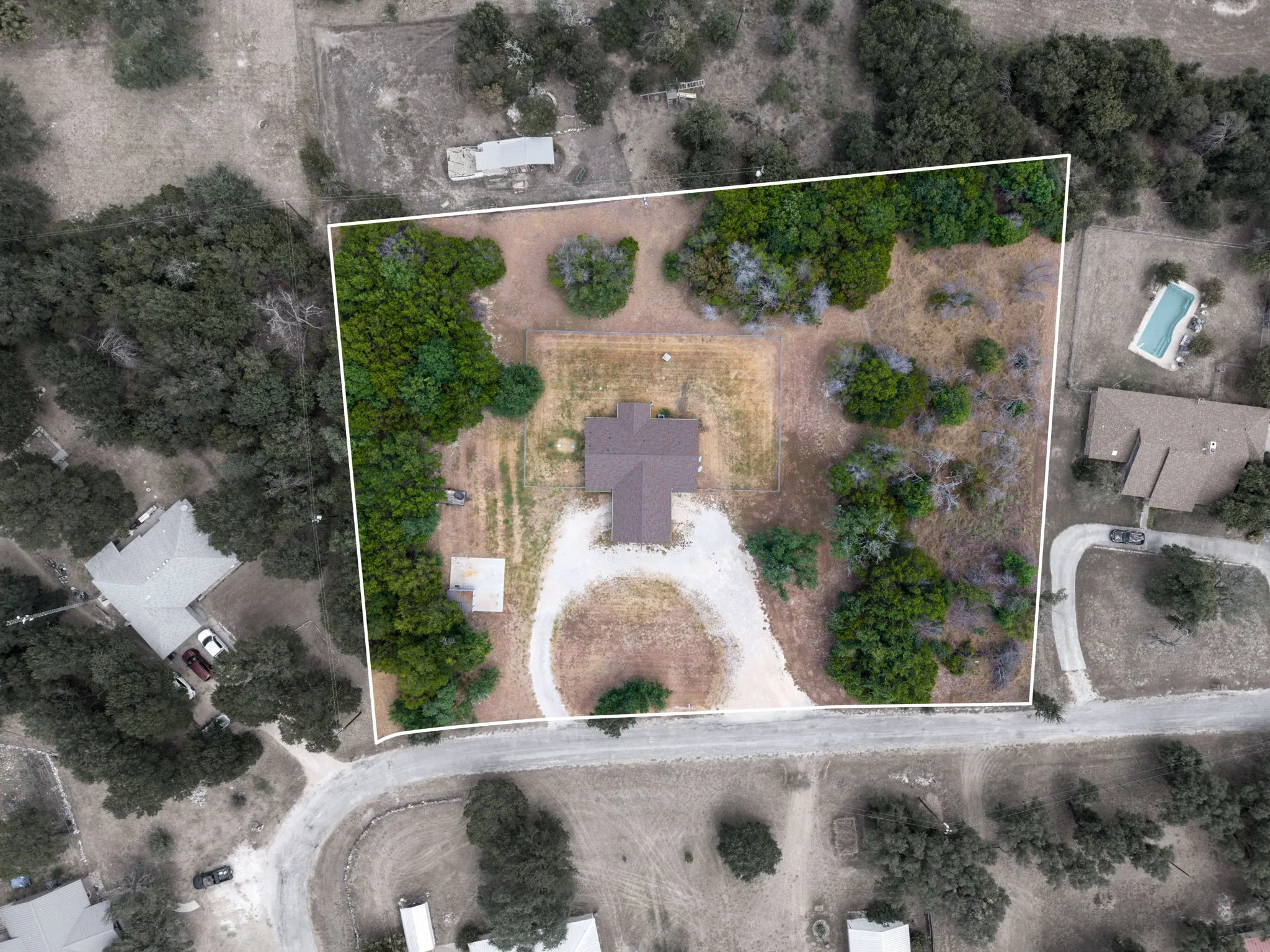 Property with expansive lot featuring mature trees and a single-story residence