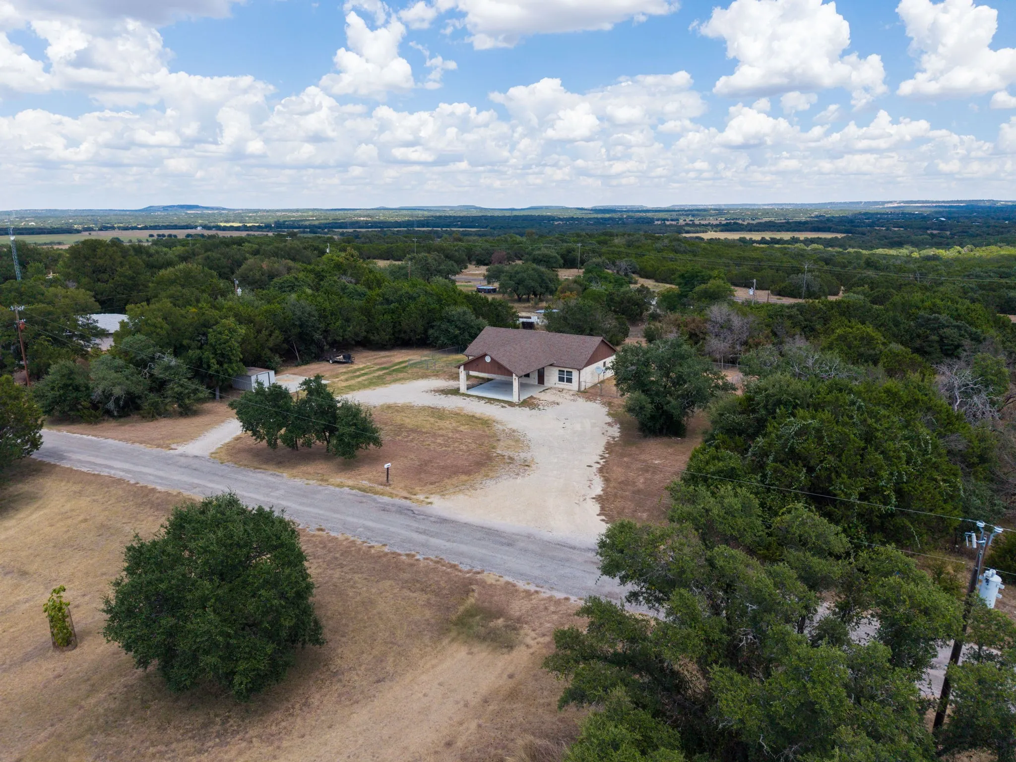 Single-story residence with a covered carport, set on a gravel lot