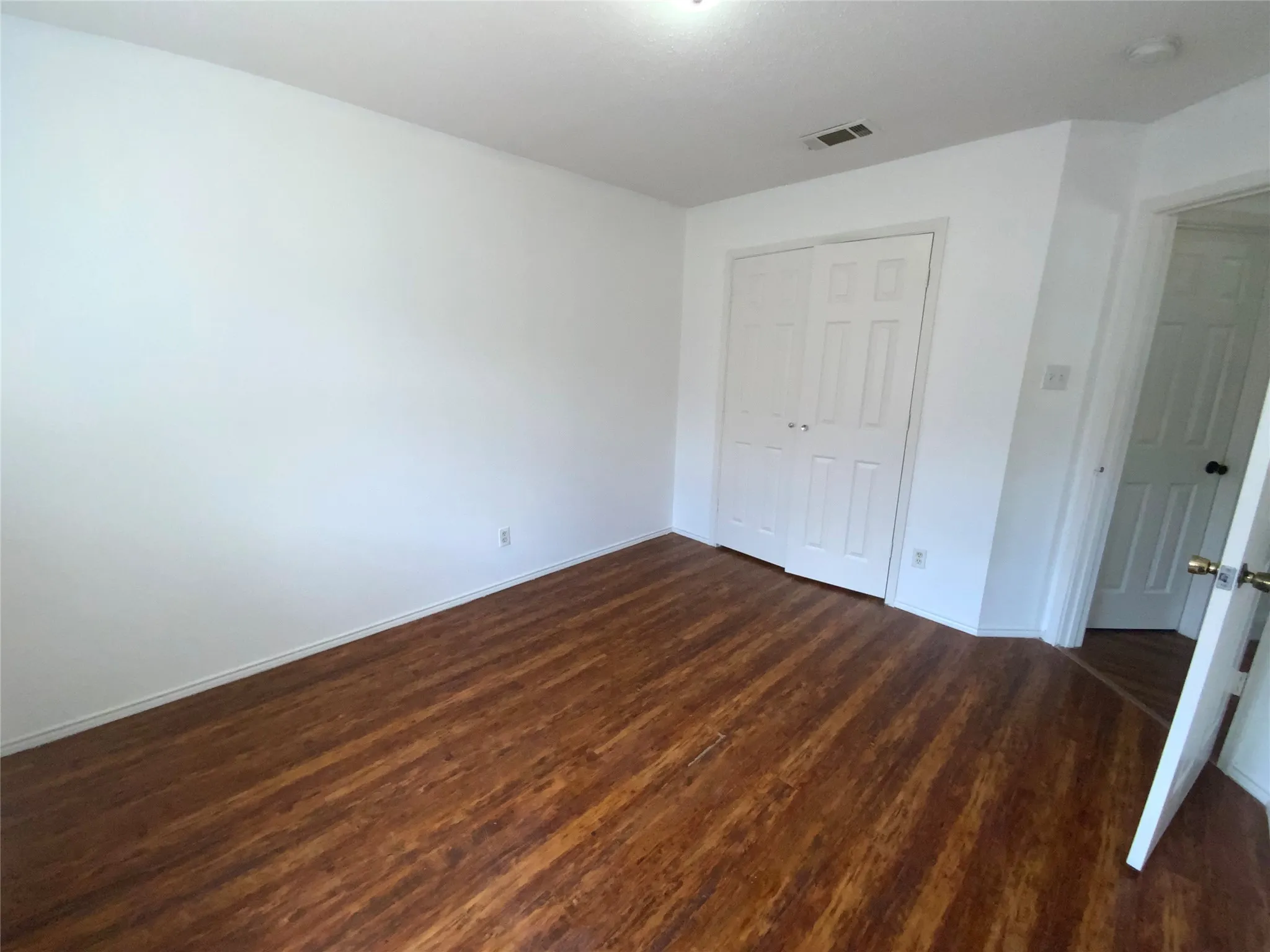 Wood-finish flooring with a neutral paint palette and bifold closet doors